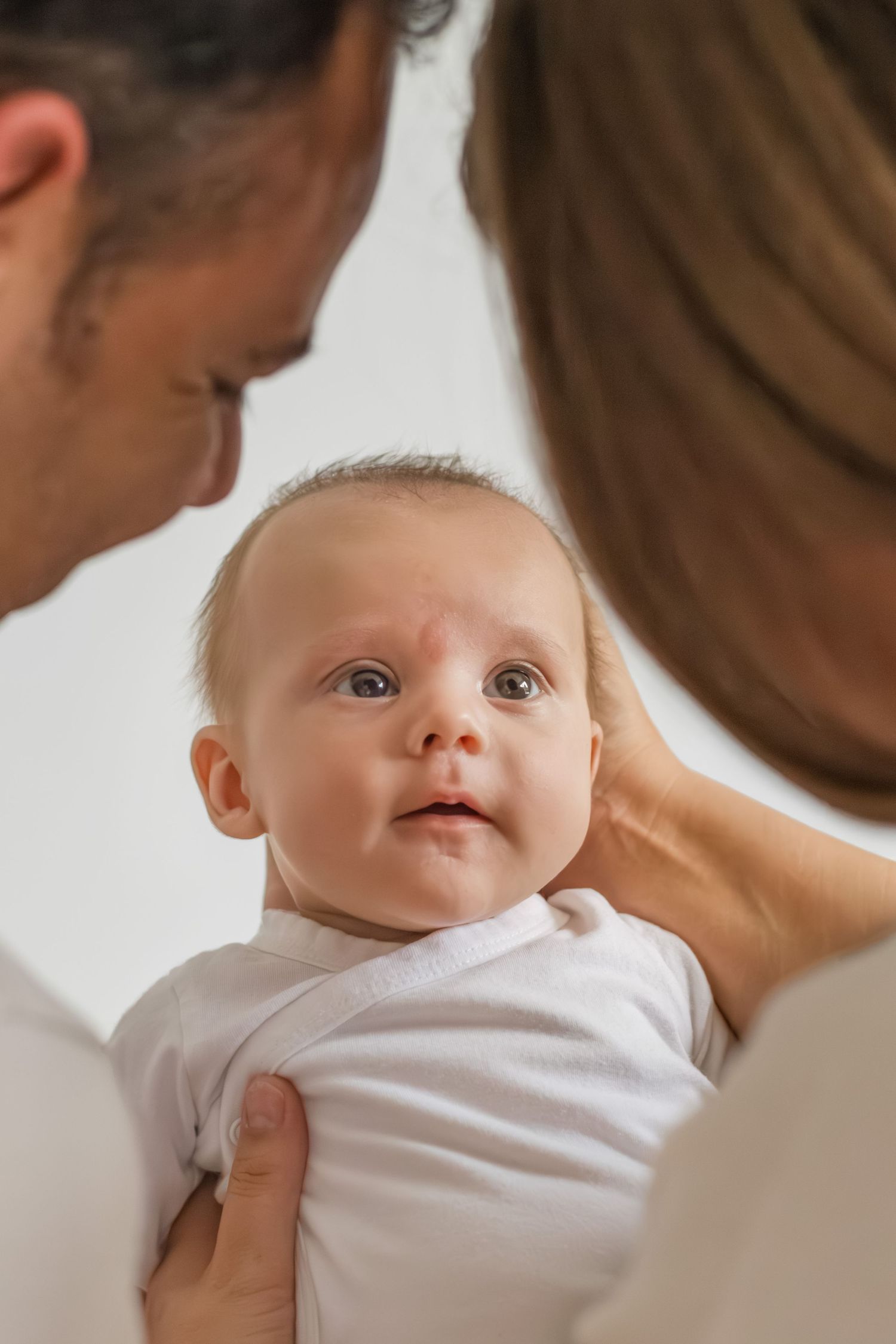 Papa en mama die vol trots en liefde naar pas geboren baby kijken in Zuid-Holland.