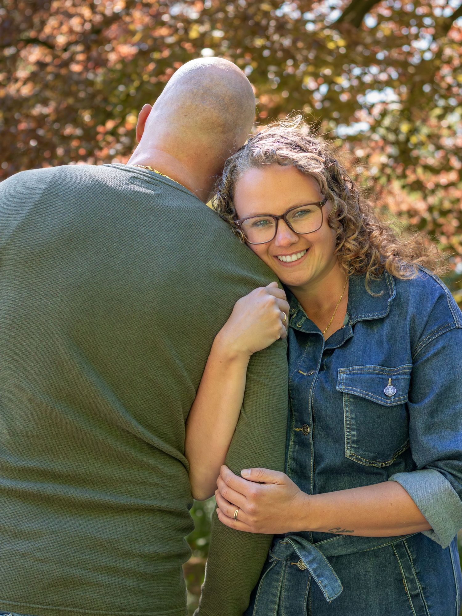 Verliefd koppel knuffelend met elkaar in park tijdens een gezinsshoot in Zuid-Holland.