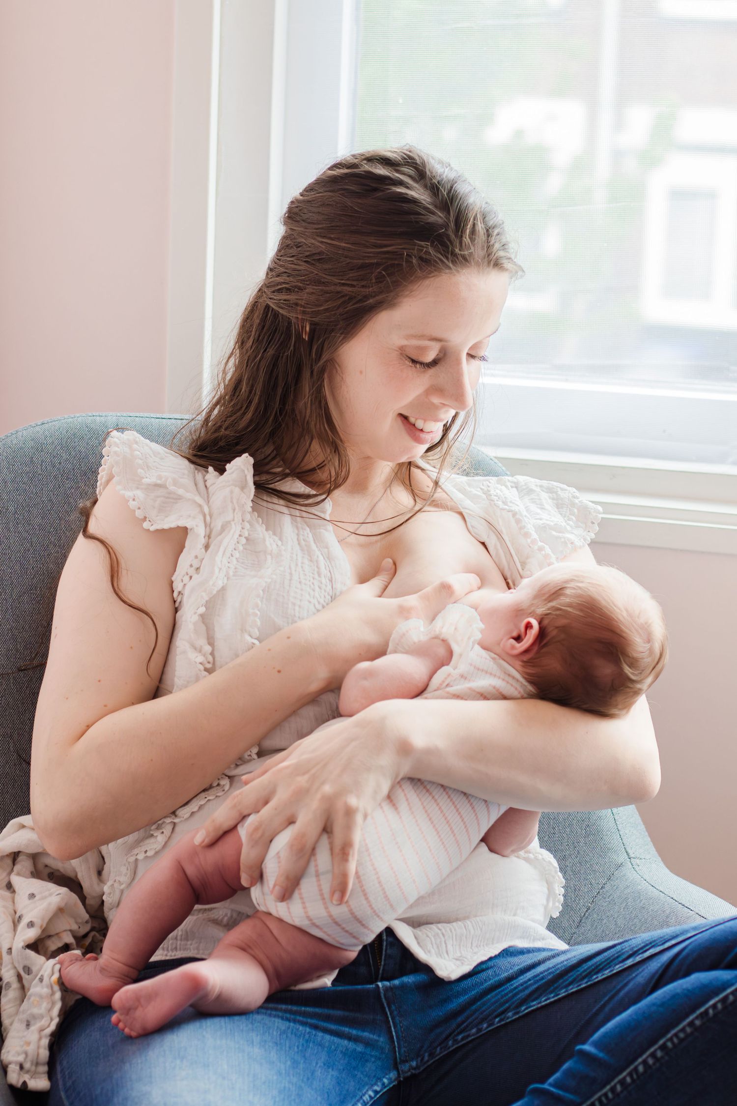 Mama die pasgeboren dochter borstvoeding geeft tijdens een newbornshoot in Zuid-Holland.