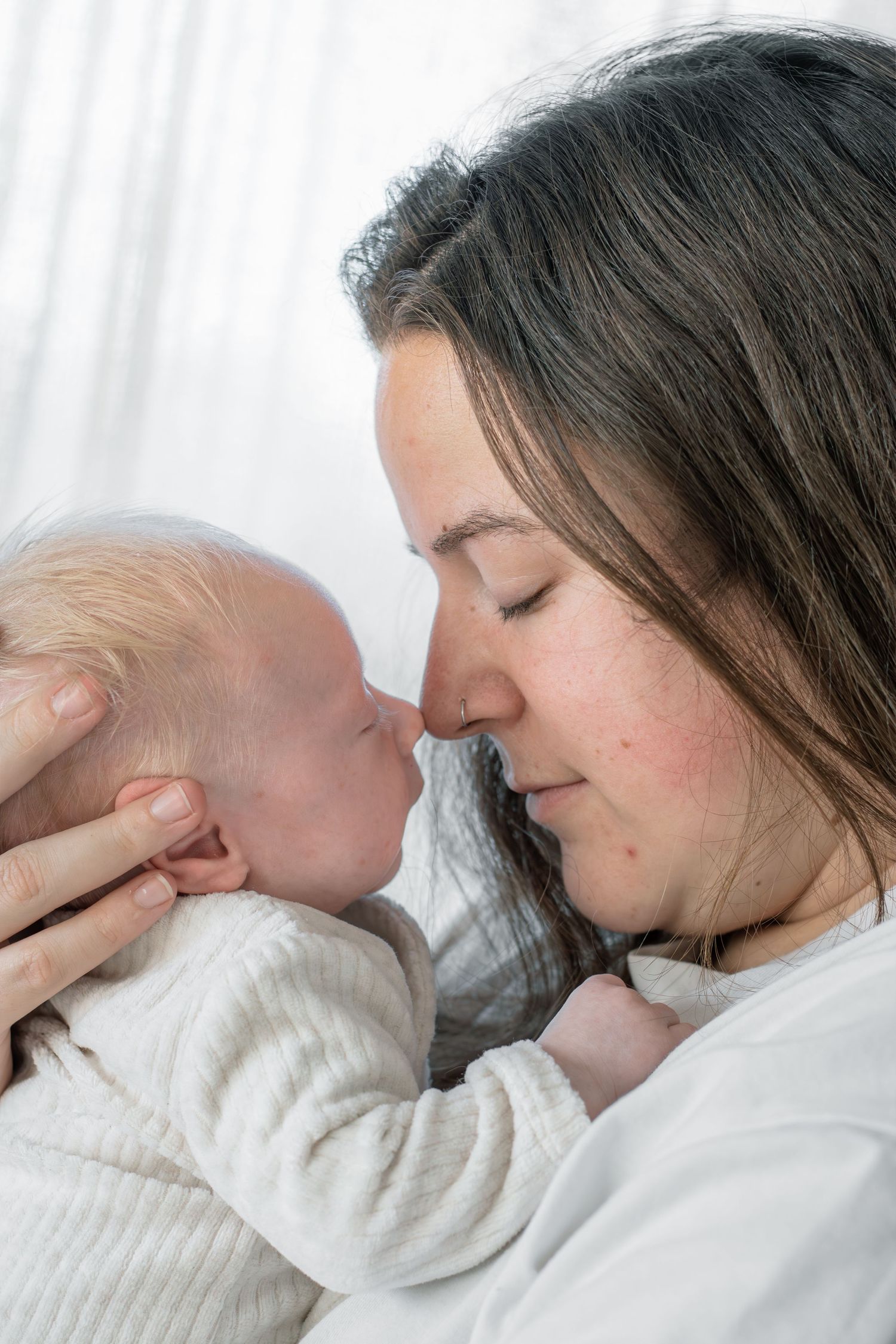 Pasgeboren baby samen knuffelend met mama tijdens een newbornshoot in Zuid-Holland.