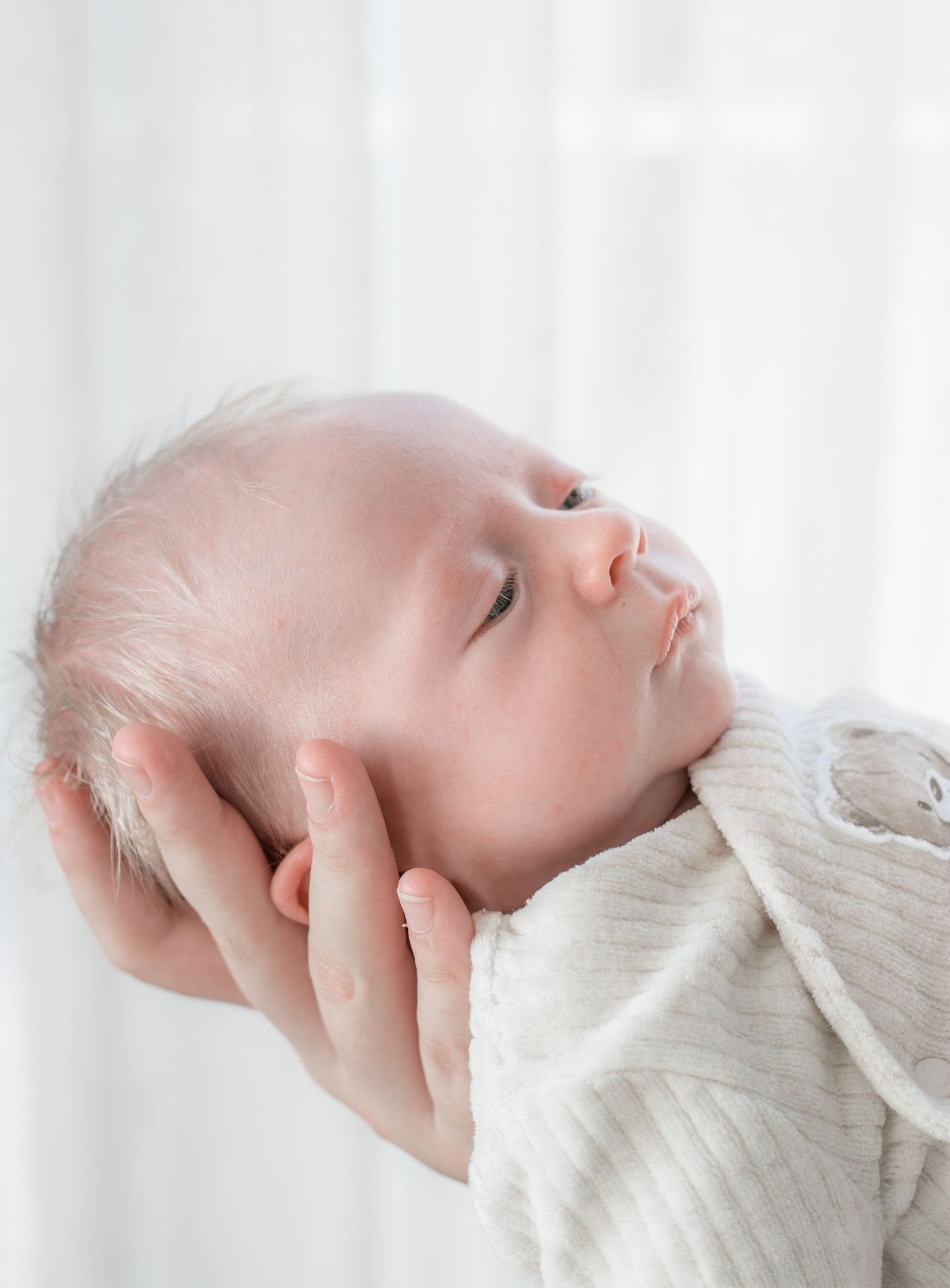 Pasgeboren baby rustig liggend in handen van mama tijdens een newbornshoot in Zuid-Holland.