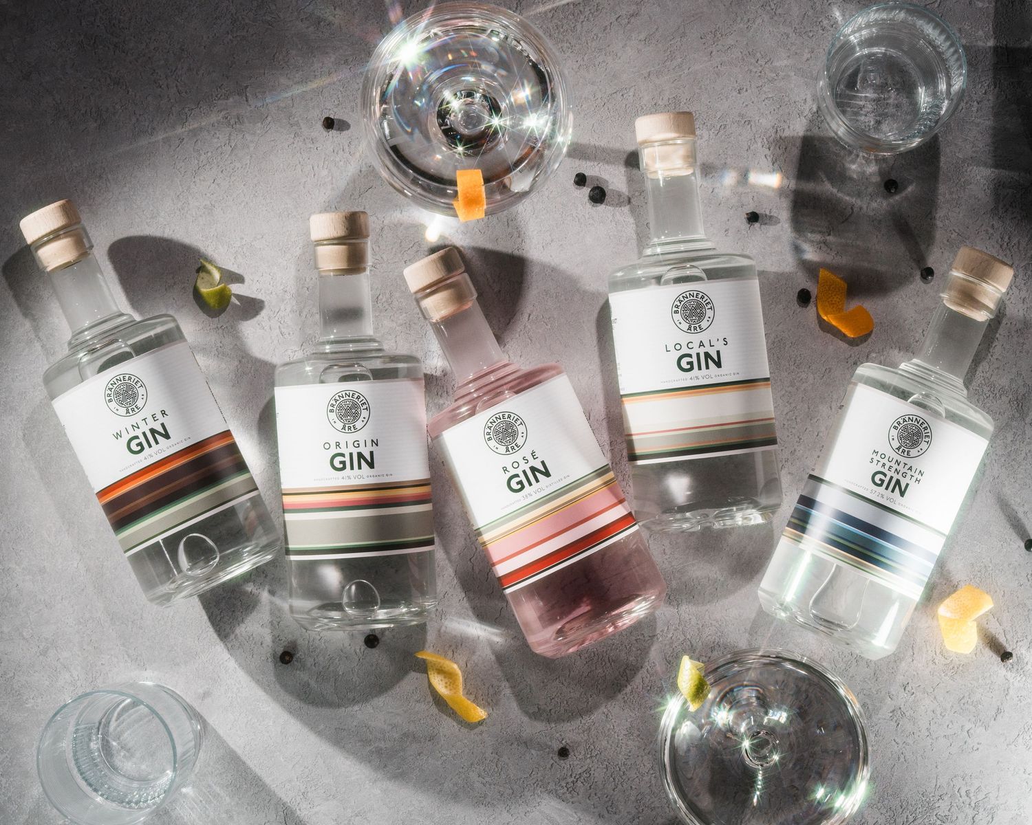 Åre Bränneriet gin bottles all in a row with gin glasses photographed in a studio in Stockholm. Fotografering av mat och dryck i Sverige