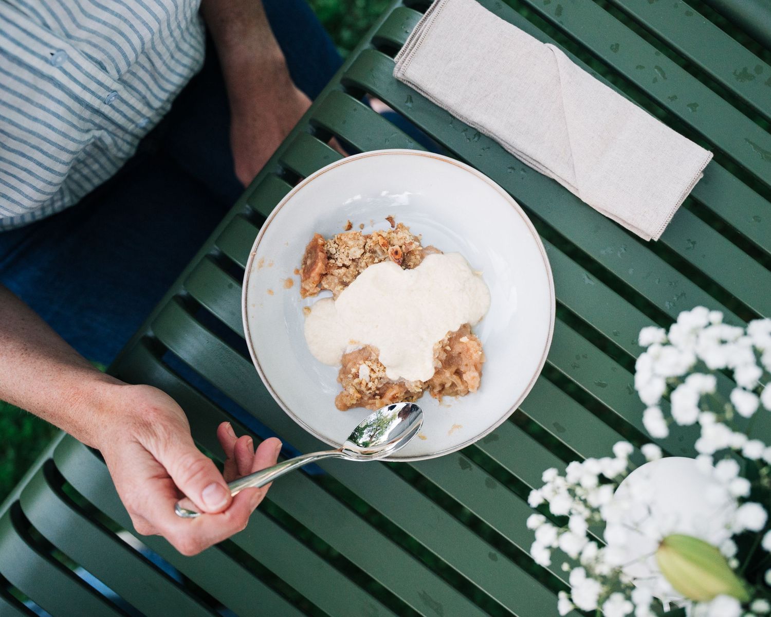woman eating apple crumble with homemade custard in her garden shot for a commercial shoot in Stockholm.
