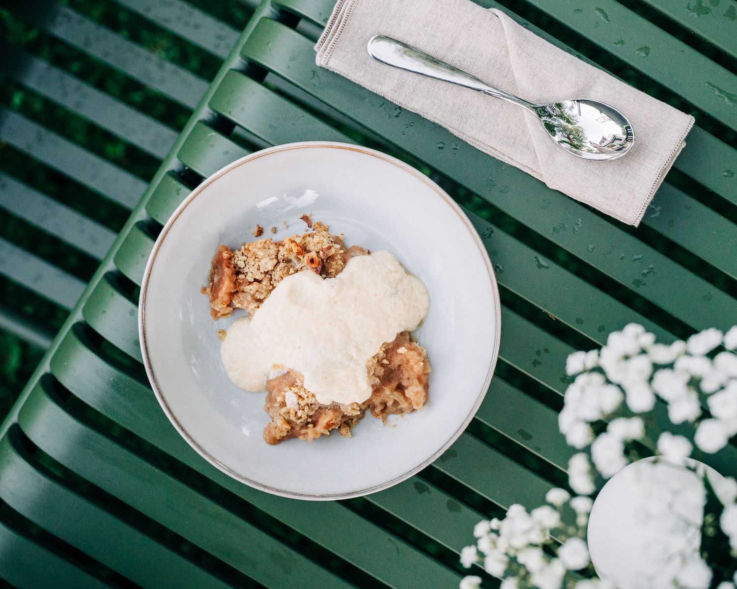 Kommersiell matfotografering i Stockholm. Apple crumble on a table outside in the garden in Sweden, a commercial photography shoot