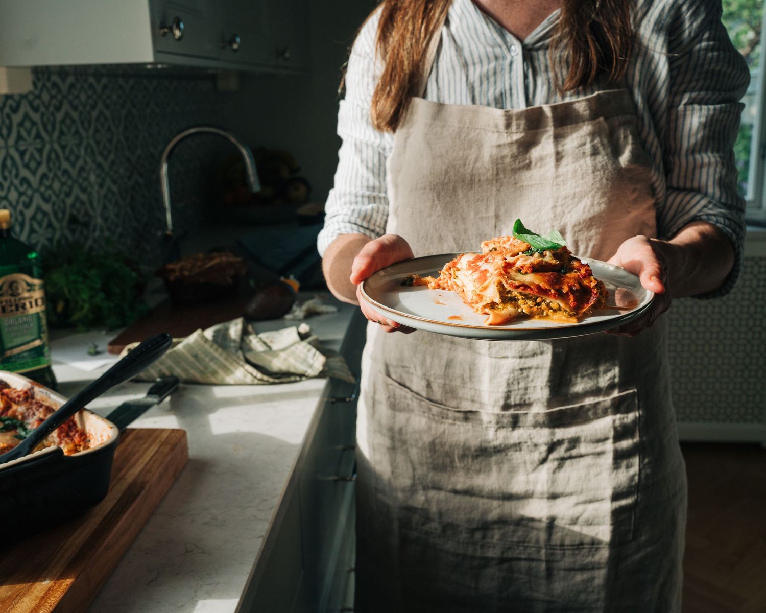 chef holding a plate of lasagna for a commercial brand photography shoot in Stockholm, Sweden. Content creation for brands
