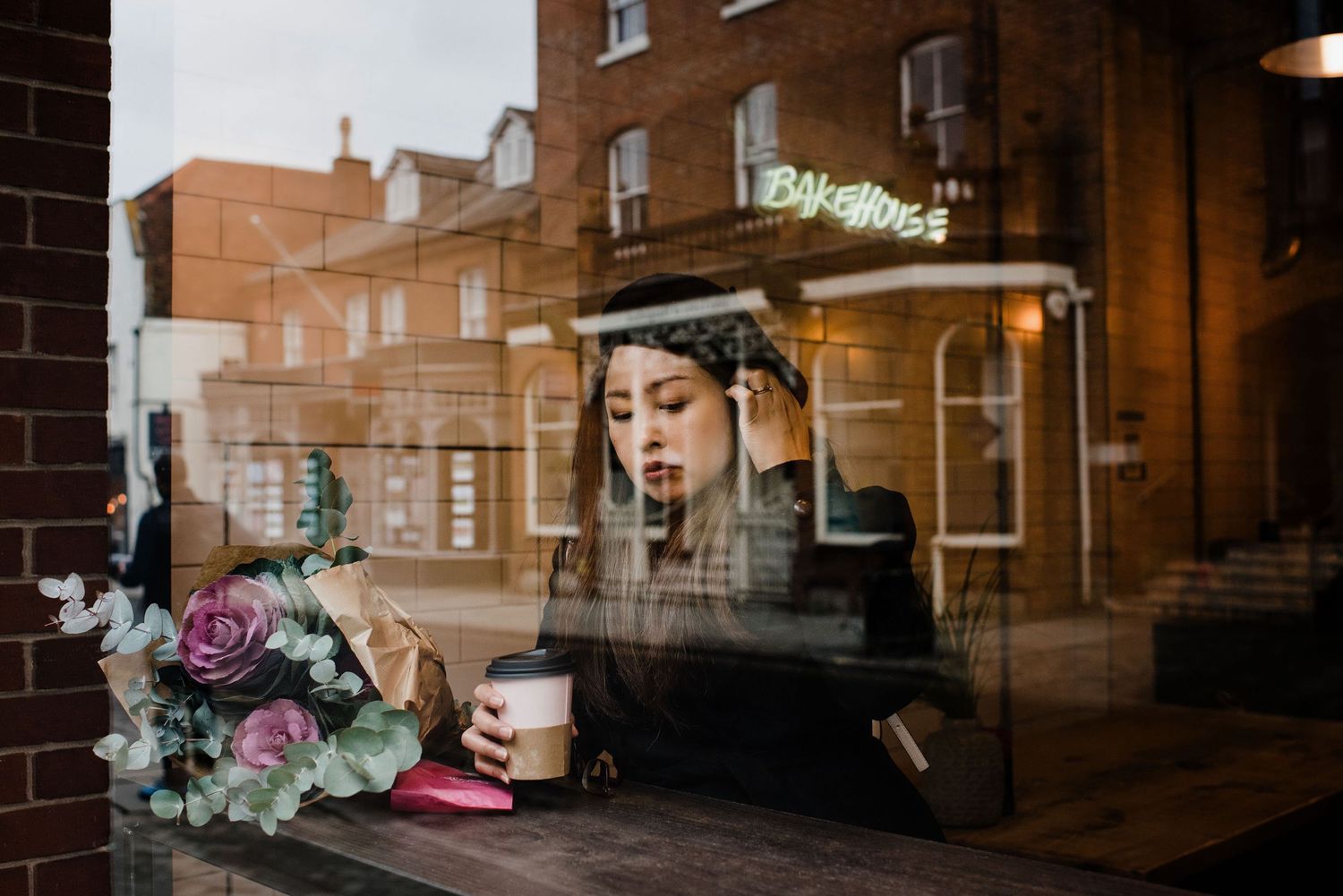 woman sat in a cafe having fika whilst in Winchester, UK. Food and beverage photographer UK
