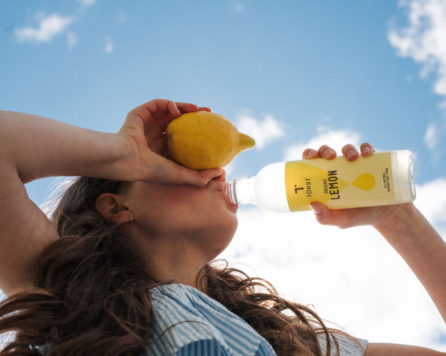 girl drinking lemon Törst organic soda whilst outdoors in Summer Stockholm commercial photoshoot