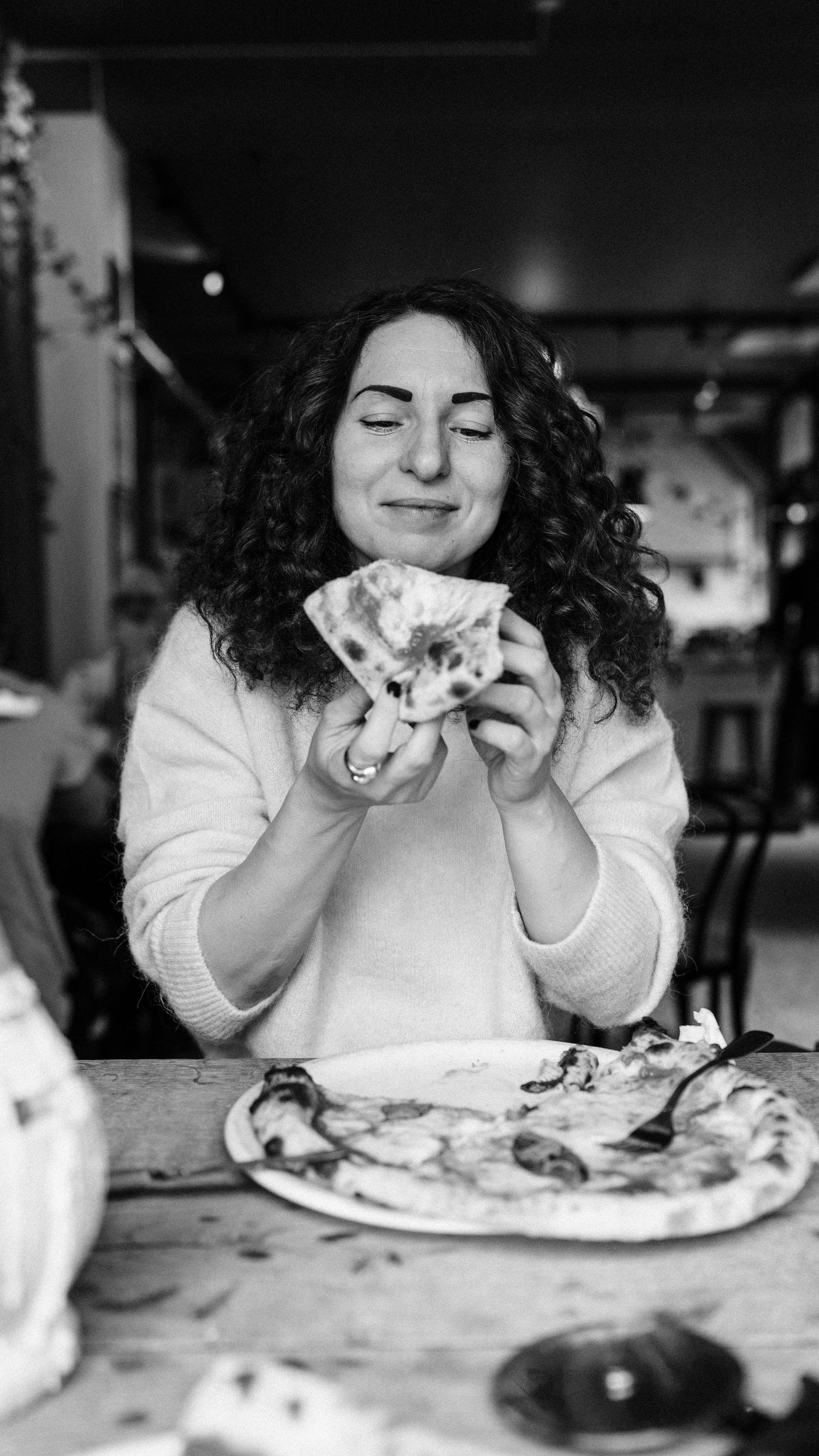 Woman eating authentic Italian pizza in a restaurant in Stockholm