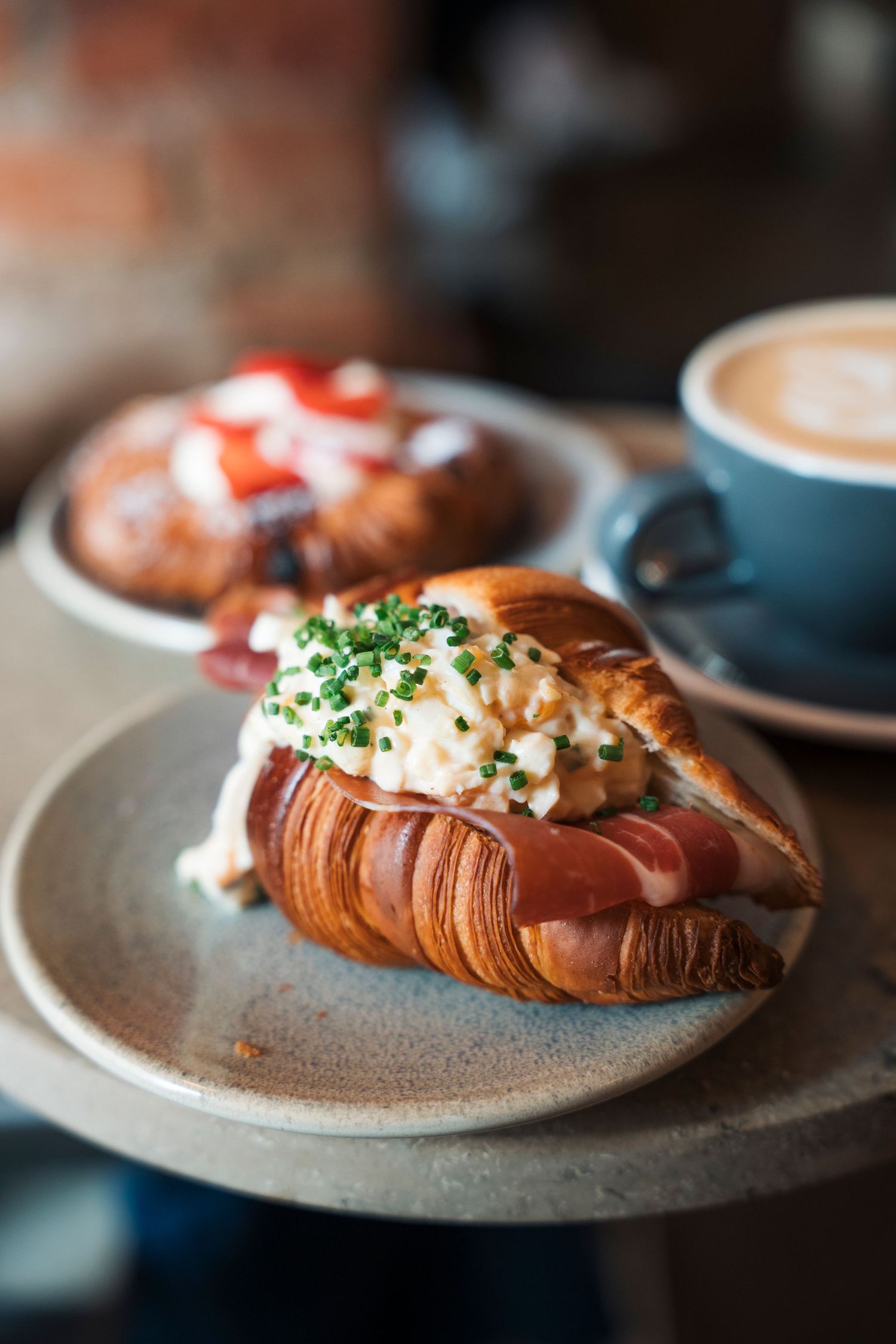 croissant filled with egg and ham on a plate in a cafe in Stockholm. Commercial food photography