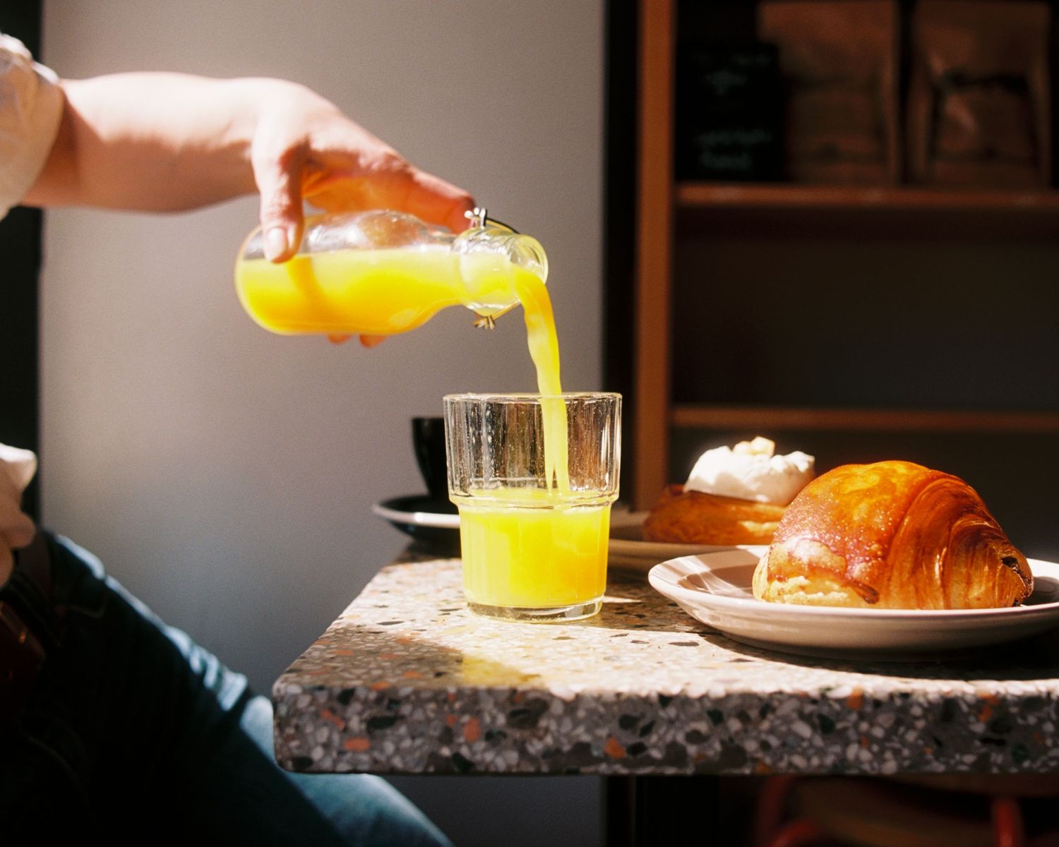 orange juice being poured into a glass in a cafe in Stockholm commercial film analogue photography Stockholm