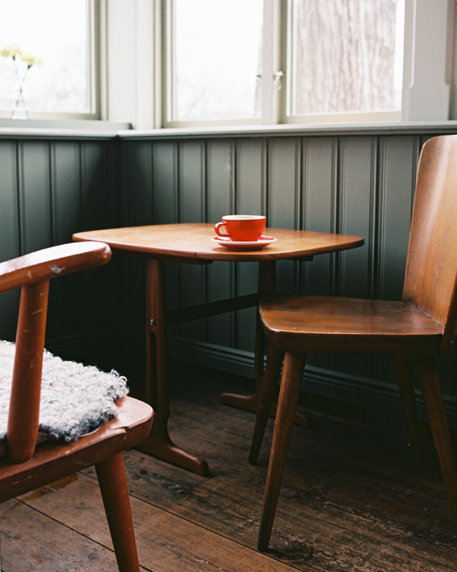 cup of coffee in a red mug on a table photographed on film in Stockholm