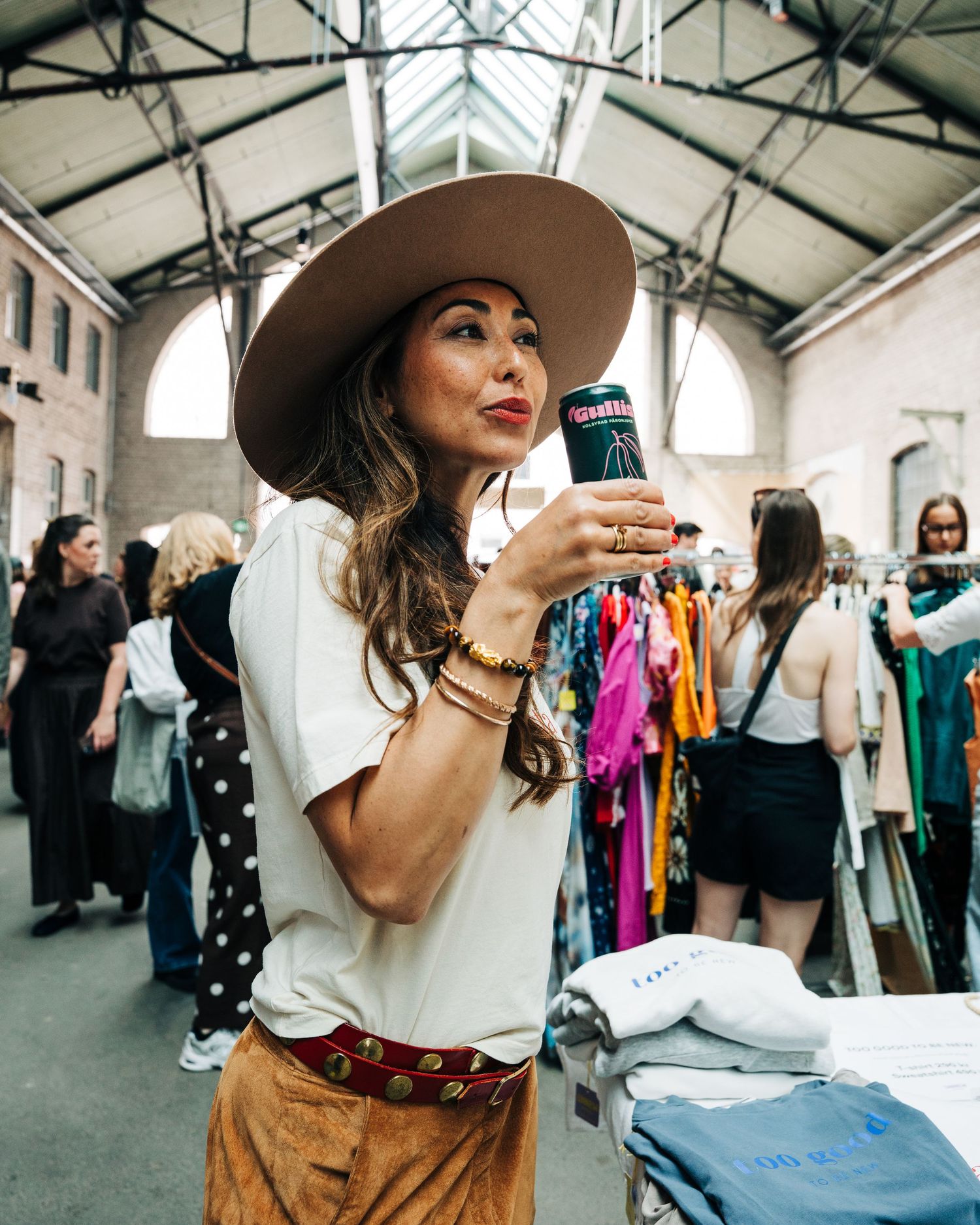 Woman drinking Gullis Pear drink at a vintage market in Stockholm Sweden. Event photography for food and beverage brands
