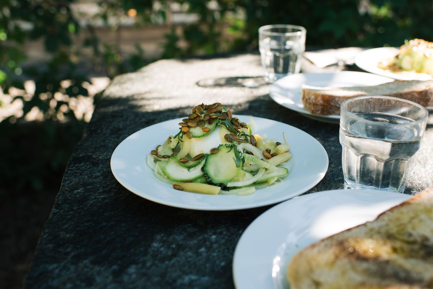 Green summer salad on an outdoor table photographed for a lifestyle photoshoot for a restaurant in Stockholm