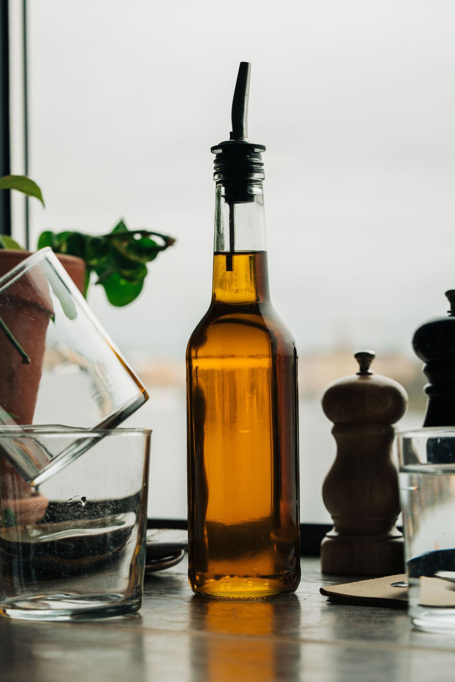 Olive oil on a cafe table over looking the water in Stockholm Photographed for lifestyle photographer Stockholm Storyteller