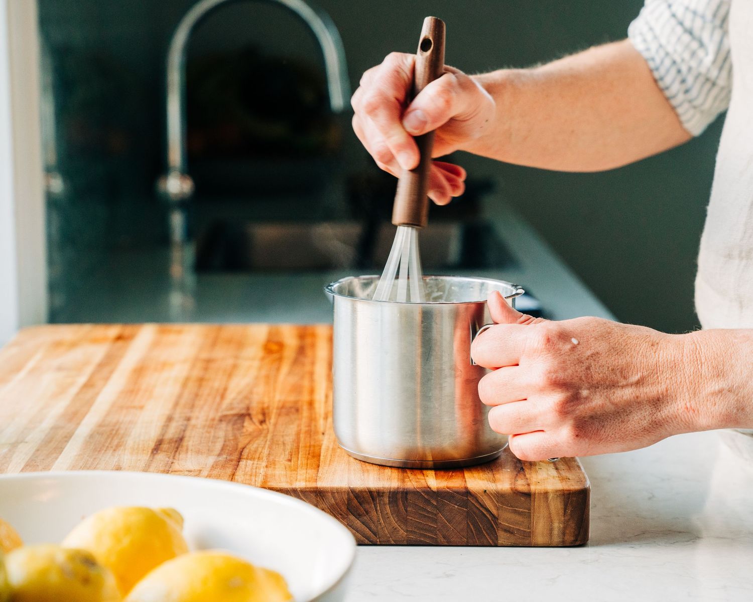 Woman whisking egg yolk ready to make homemade custard for a commercial photographer shoot in Stockholm