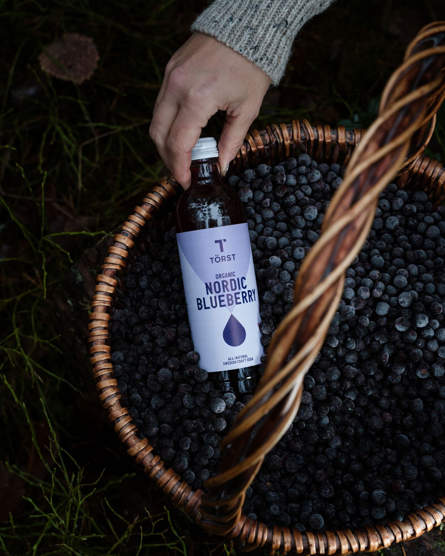 woman holding a bottle of nordic blueberry natural organic Törst drink, a commercial photoshoot in Stockholm, Sweden