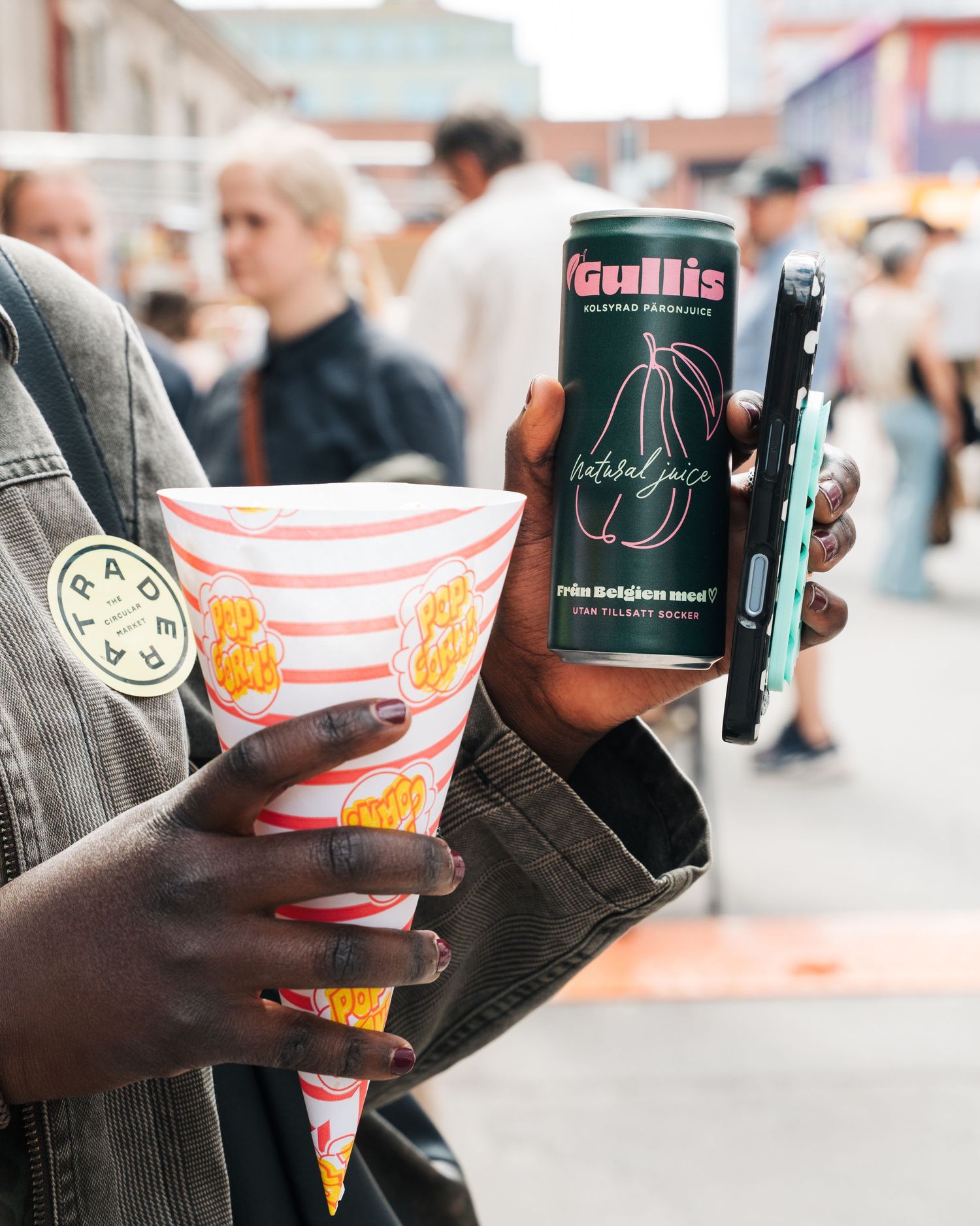 girl holding a can of Gullis pear drink and popcorn at Eken Market in Stockholm, Sweden. Brand and event Photography