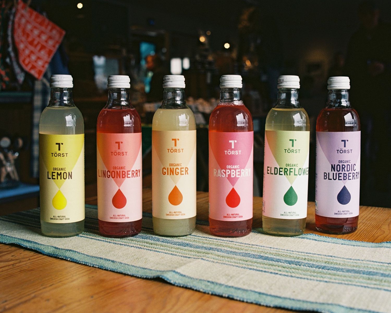 Bottles of Törst photographed on a table in a cafe for brand photography on film