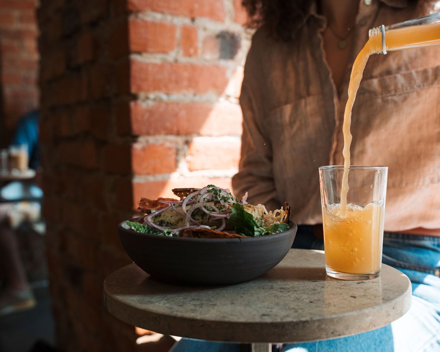 Äpplemust being poured into a glass at a cafe in Stockholm, photographing lifestyle for cafes and restaurants in Stockholm