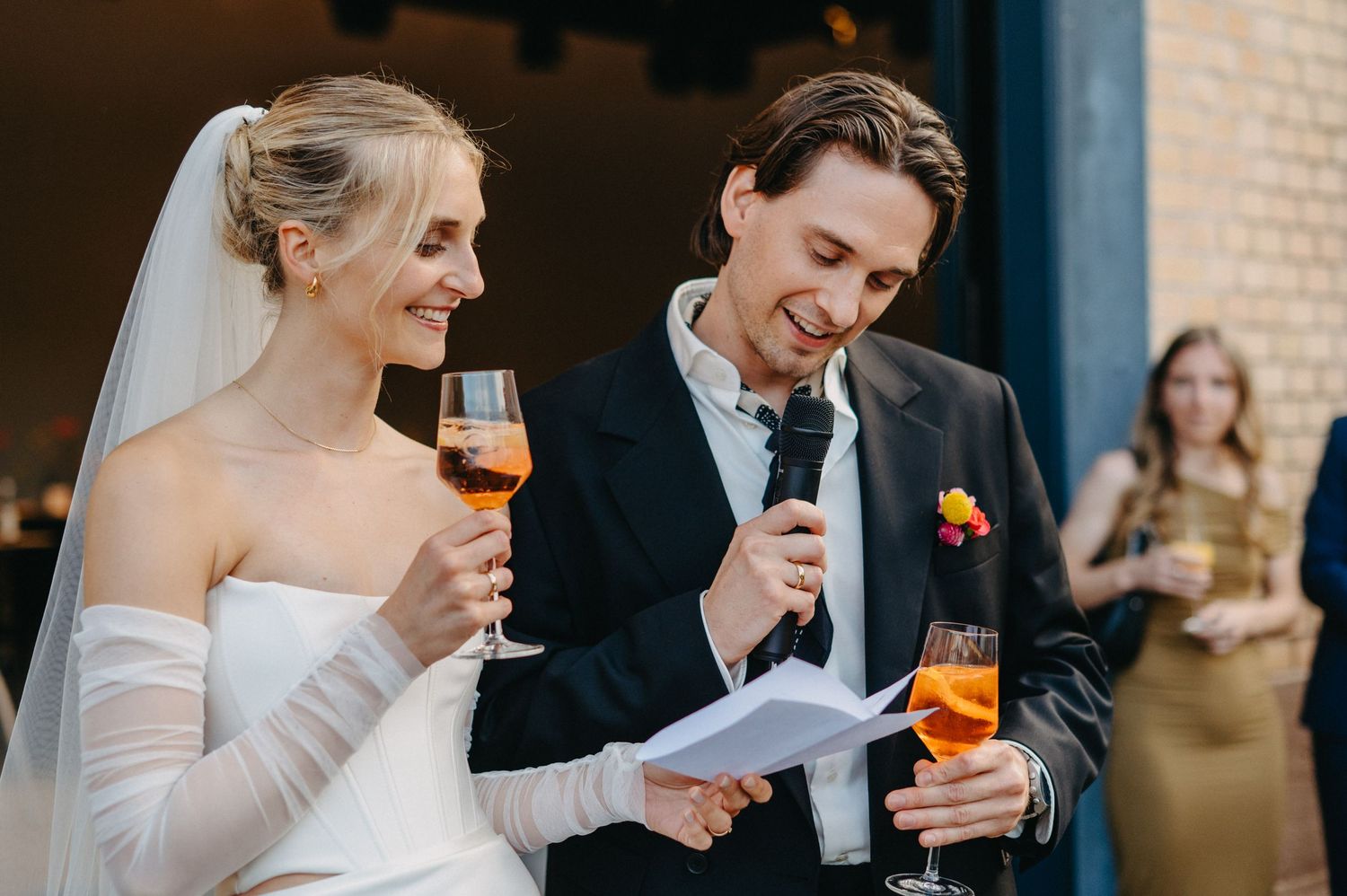 Elegant wedding reception scene with guests toasting and drinking champagne in formal attire.