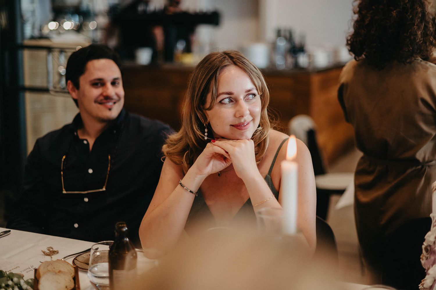 Candid moments captured during an indoor wedding celebration with warm lighting and smiles.