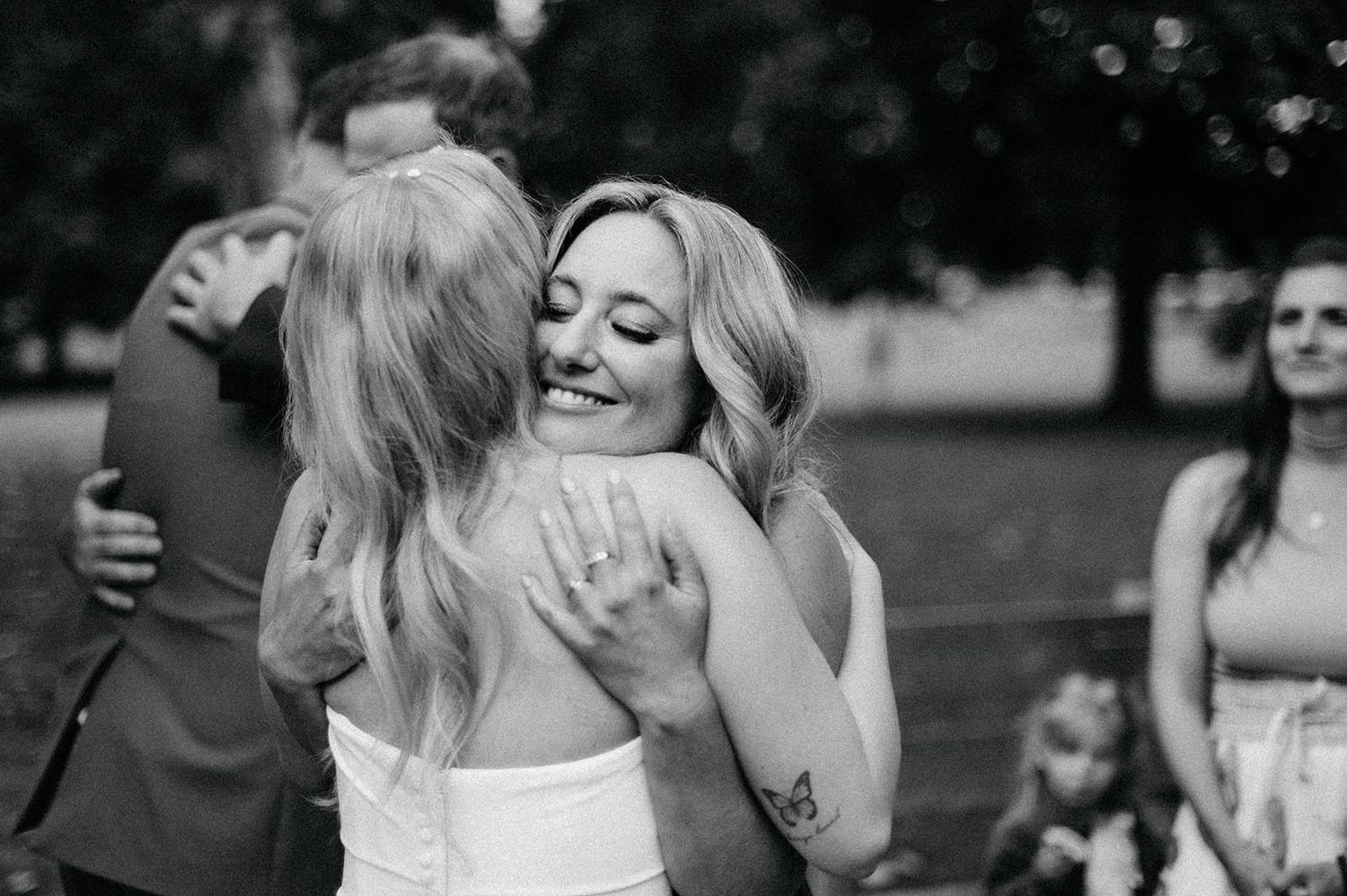 A sequence of black and white photographs showing two people embracing in an emotional outdoor celebration moment.