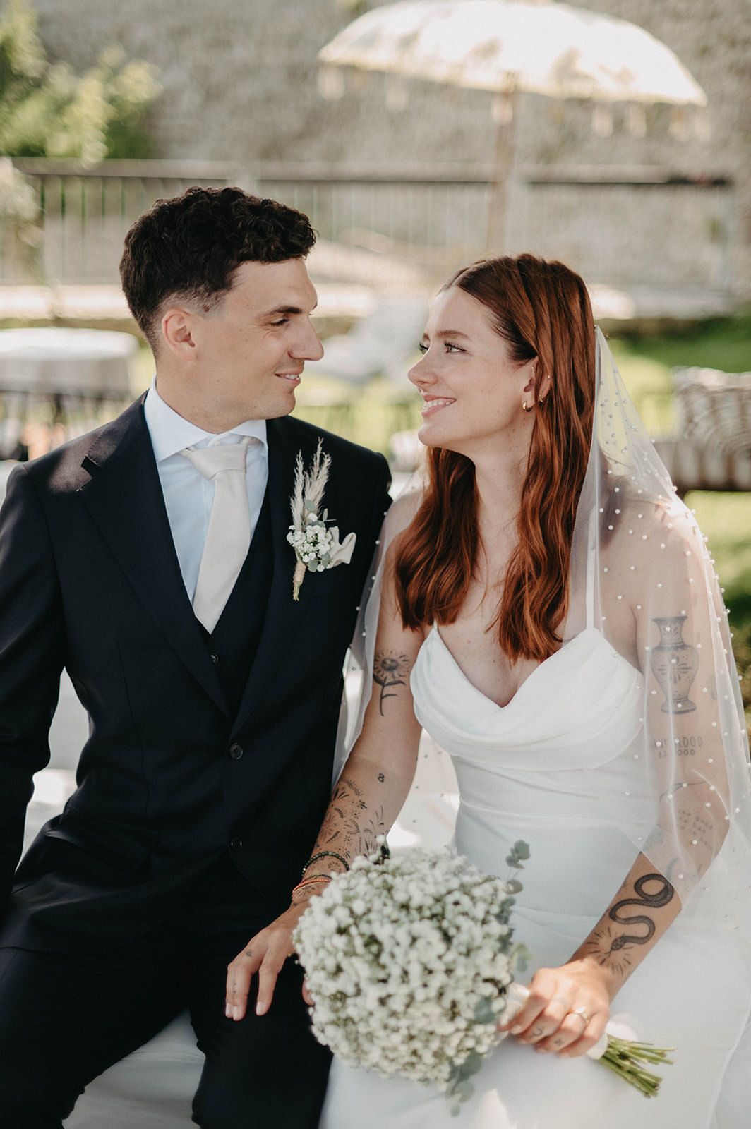 A romantic wedding couple shares intimate moments in a series of black and white outdoor portraits with baby's breath bouquet.