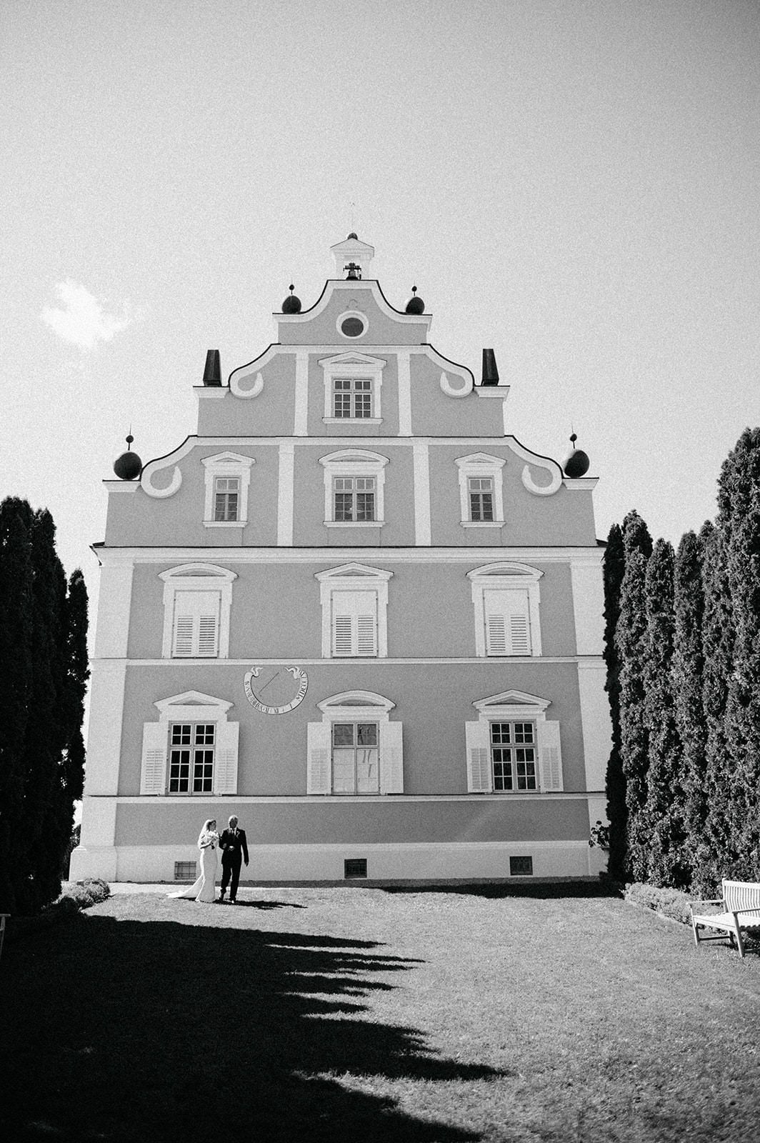 Black and white photo of a grand historic building with ornate stepped gable facade and symmetrical windows in European style.
