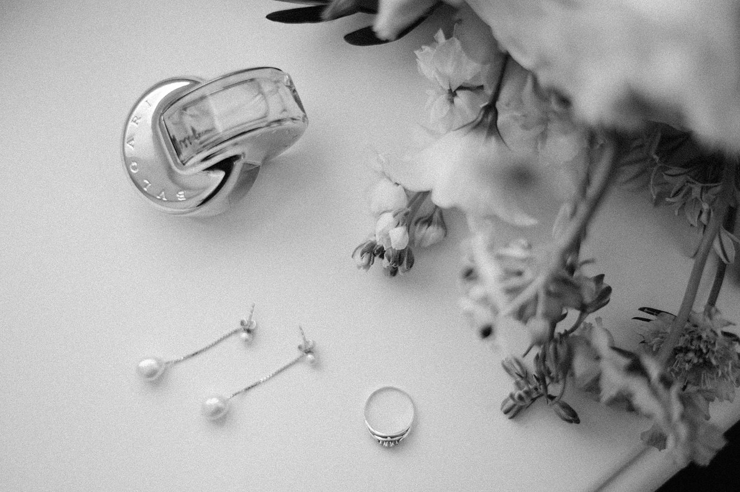 Delicate white cotton flowers with soft fluffy buds and stems arranged against a light background.