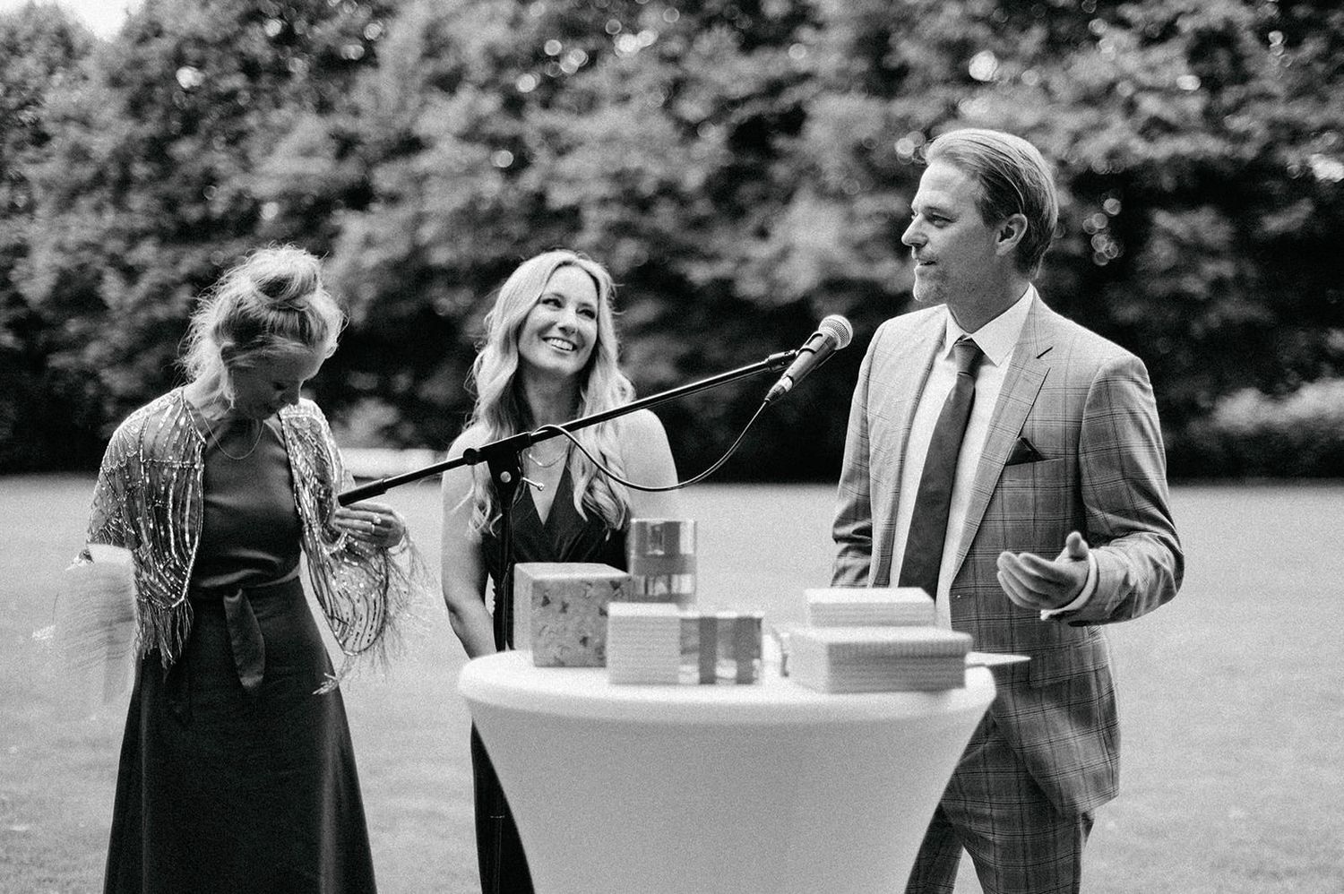 Black and white candid photos show guests mingling and socializing at an elegant outdoor event.