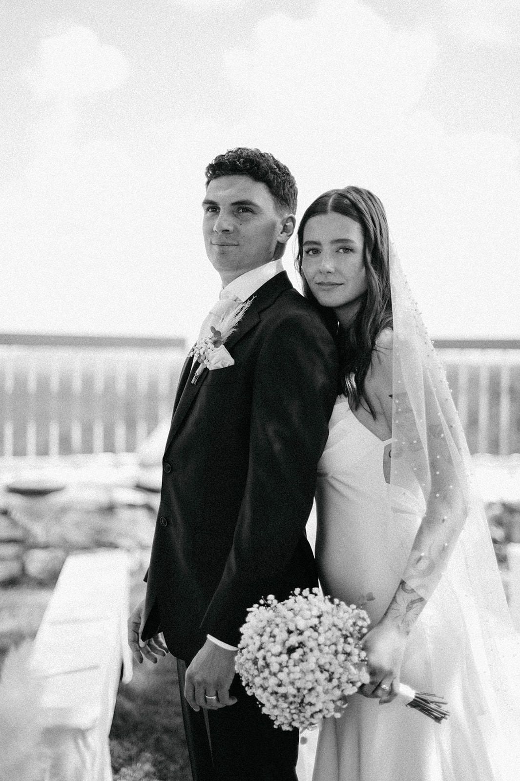 A black and white wedding photo series showing a couple embracing outdoors with a white bouquet.