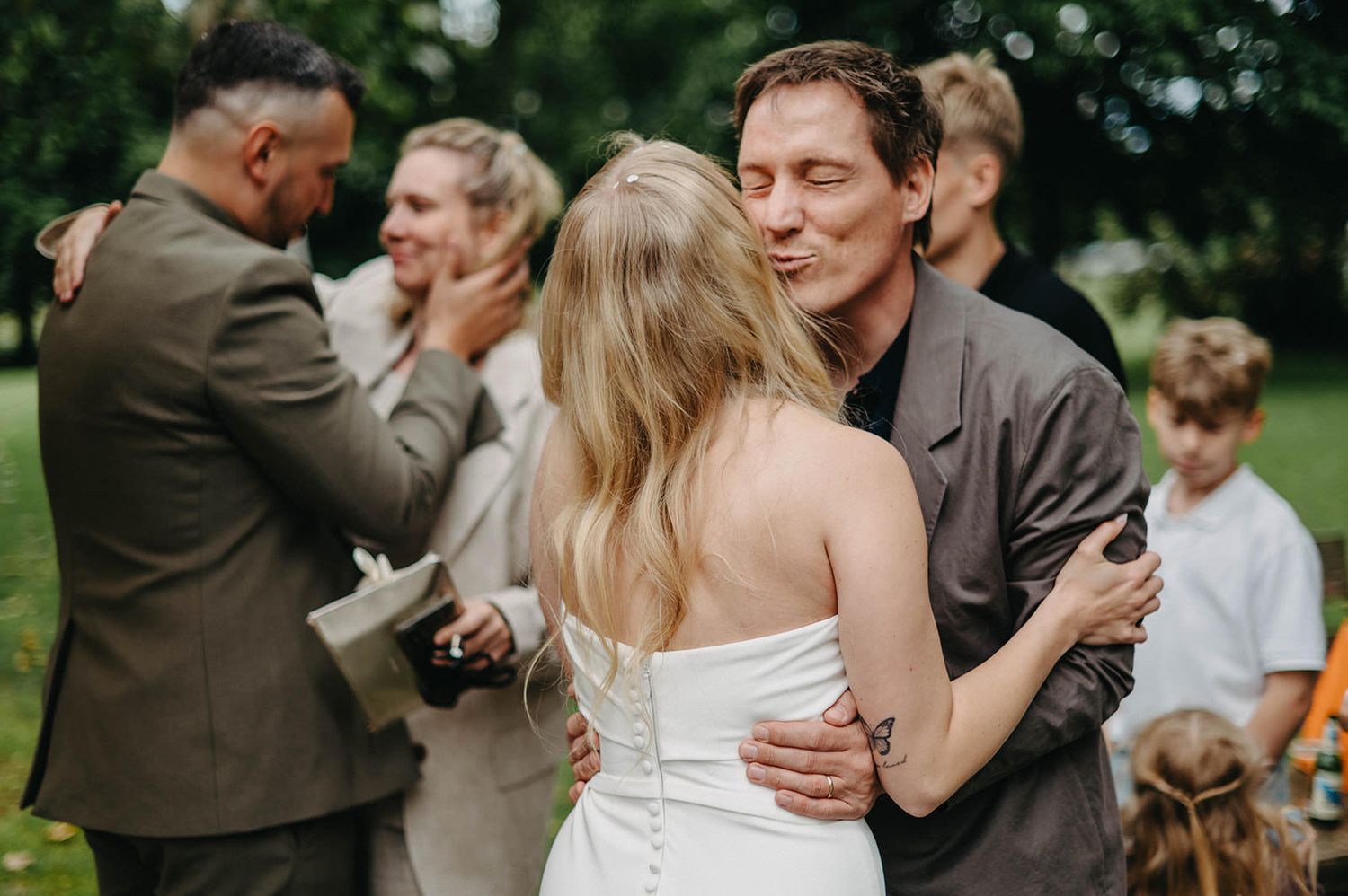 A series of candid wedding moments showing couples embracing and dancing at an outdoor reception.