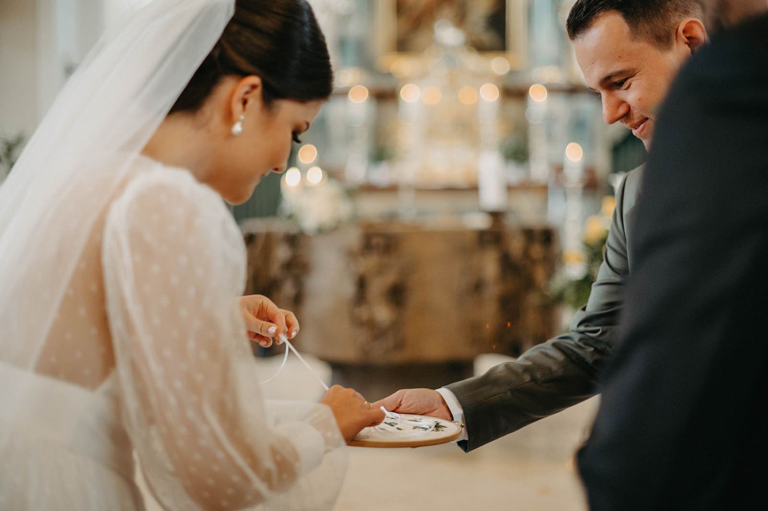 A couple exchanges wedding rings during an elegant indoor ceremony with soft lighting and romantic ambiance.