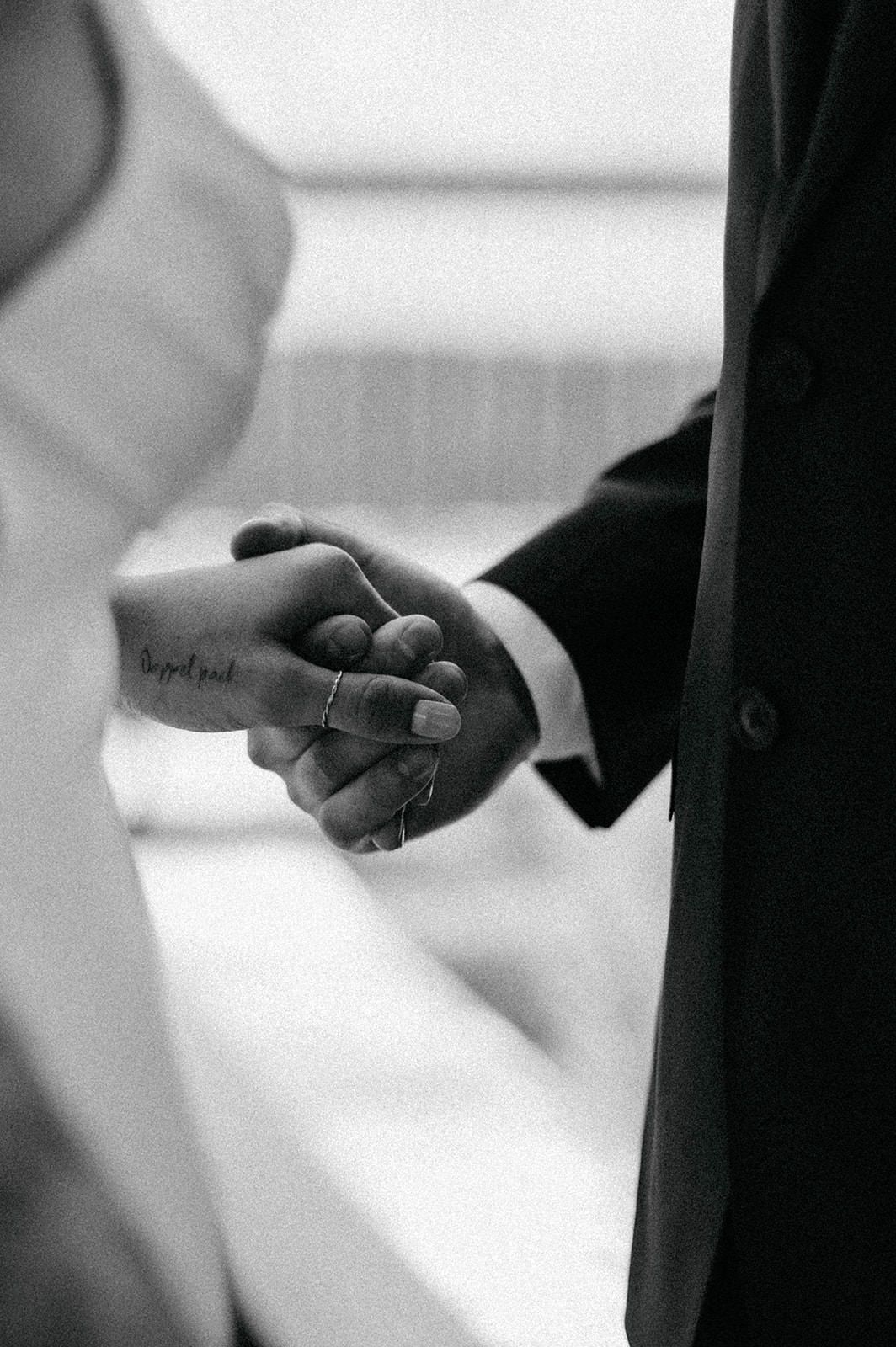 Close-up of hands exchanging wedding rings during a ceremony.