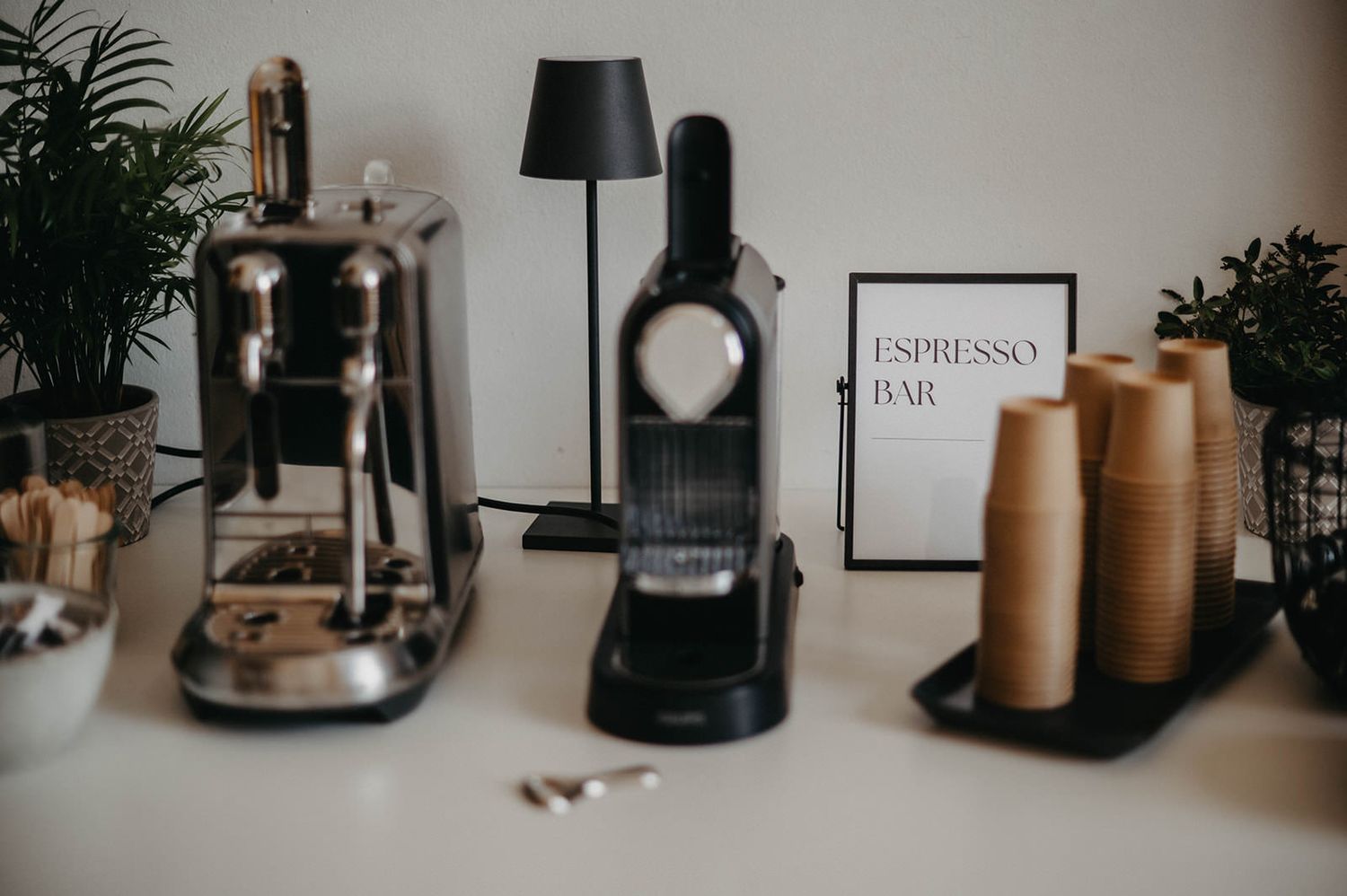 Modern minimalist kitchen counter with coffee making equipment and espresso accessories arranged neatly.