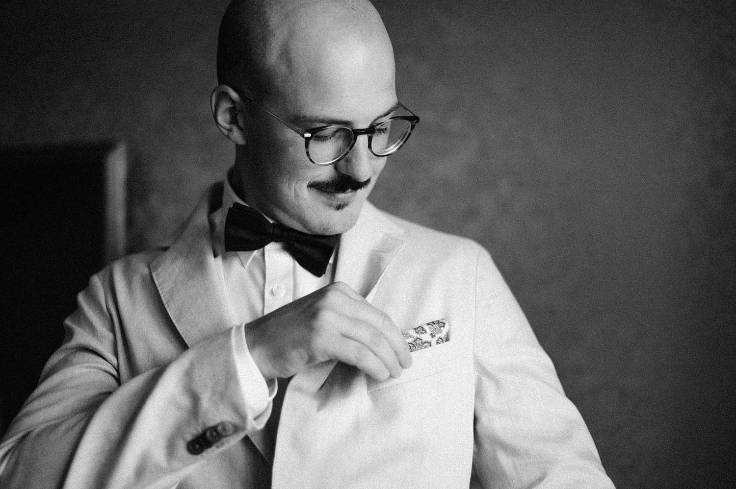 A series of black and white portraits showing someone in a white shirt with glasses in various contemplative poses.