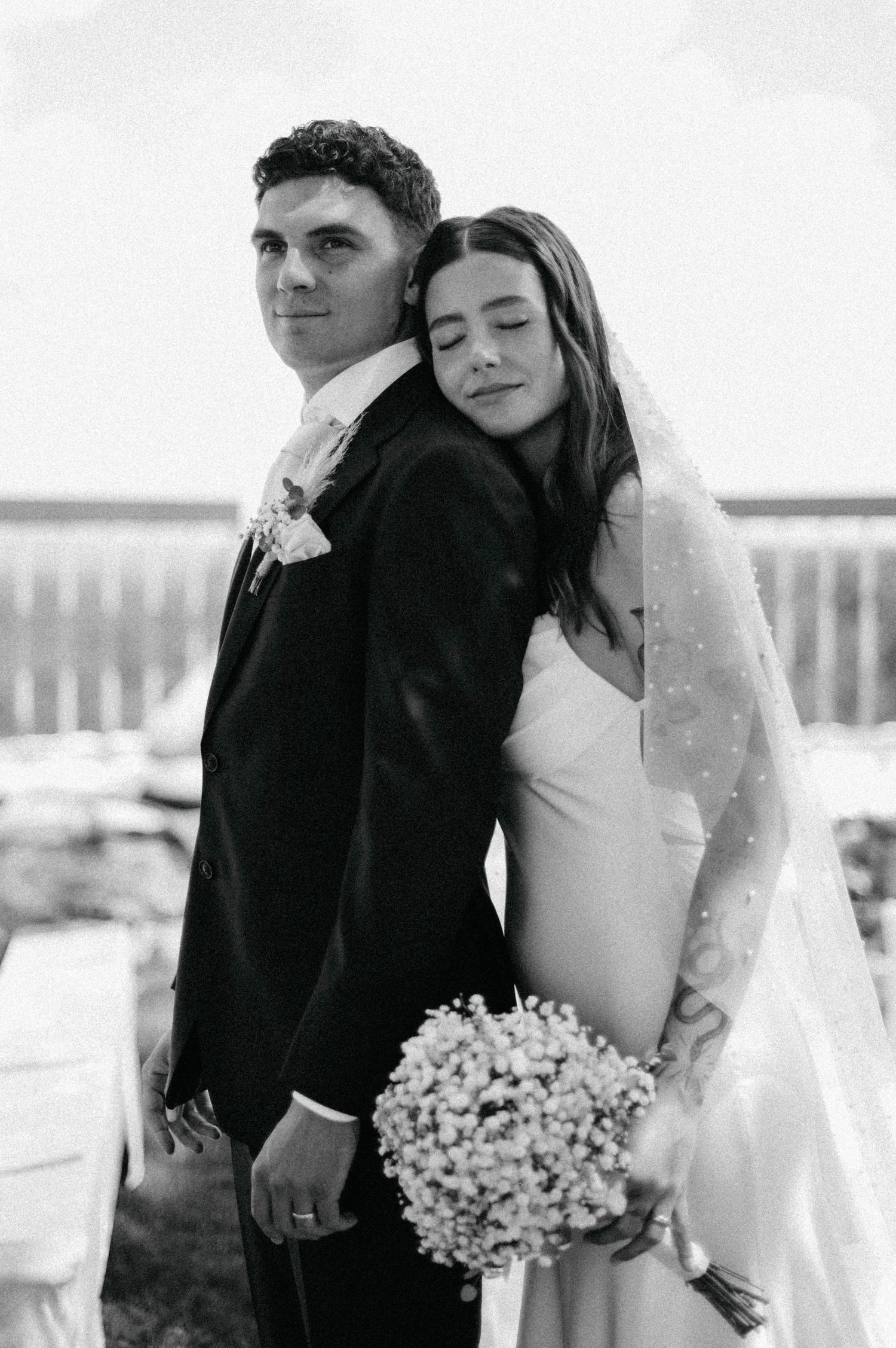 Intimate black and white wedding portrait with a bouquet of baby's breath flowers.