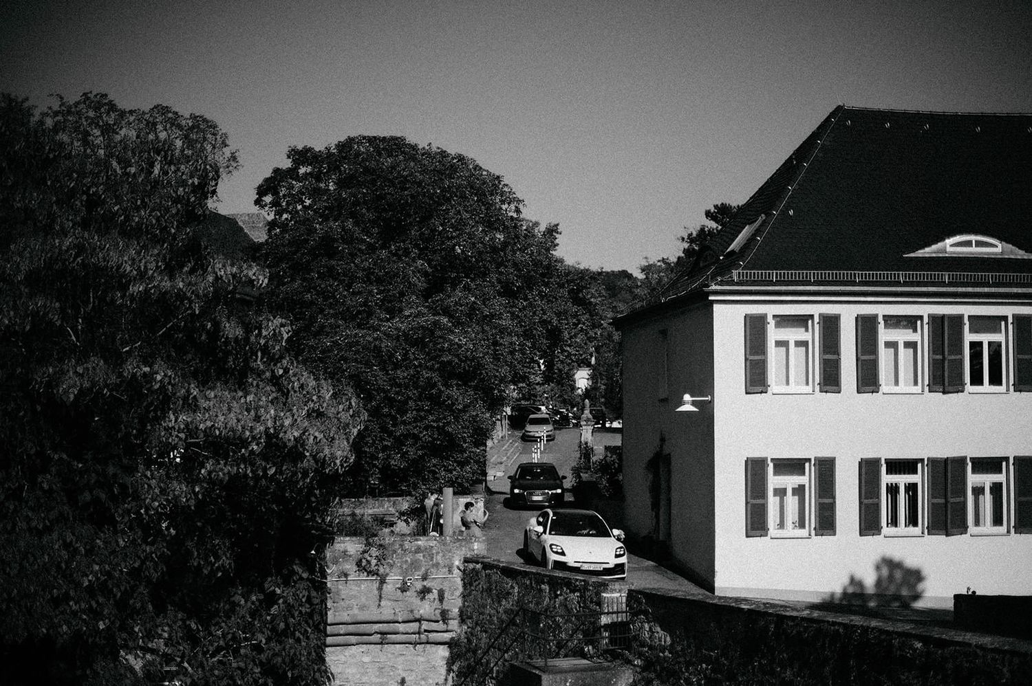 Vintage black and white aerial photograph showing a row of suburban houses with dark roofs along a residential street.
