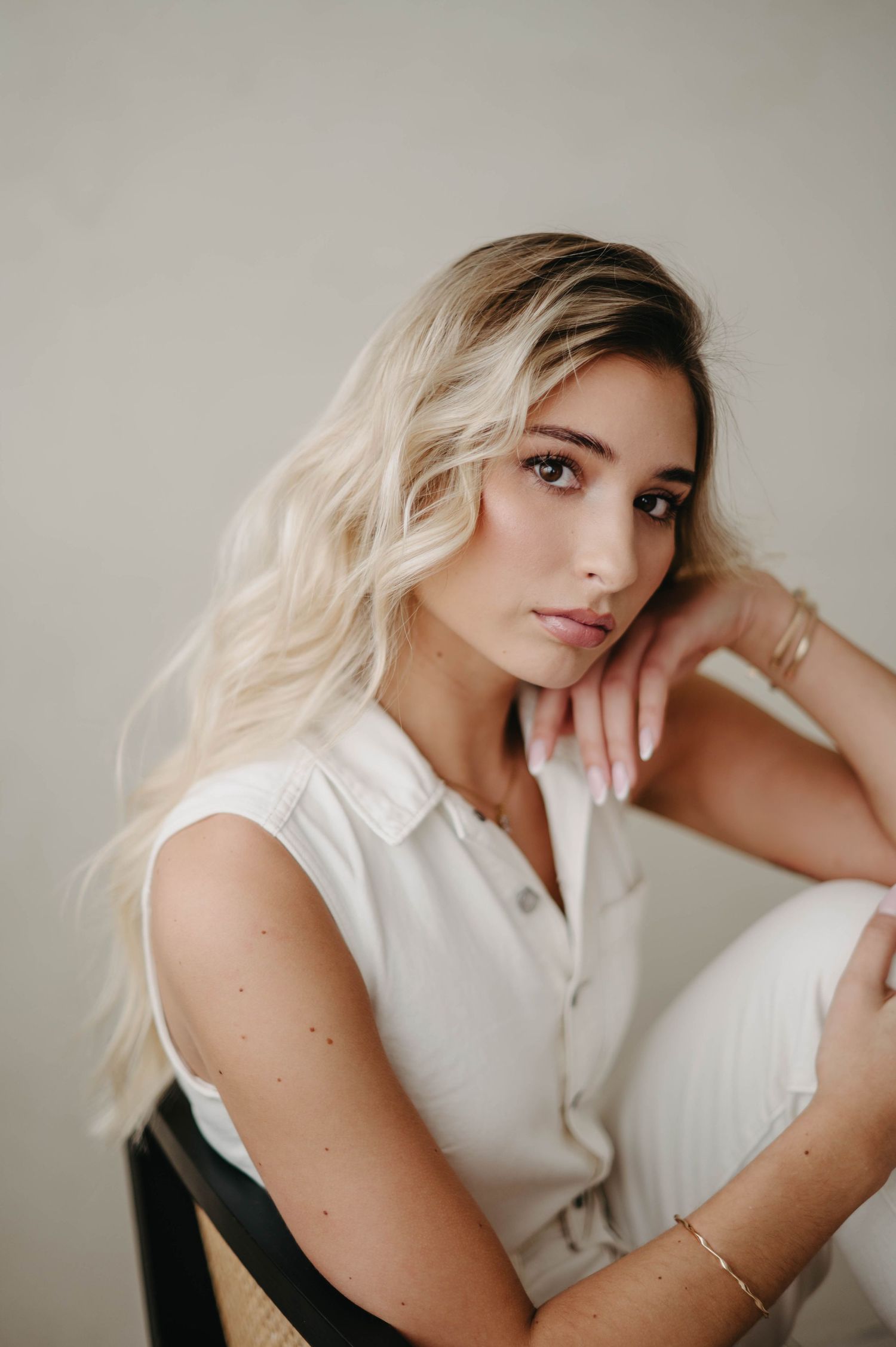 Artistic portrait showcasing blonde hair and a crisp white sleeveless top.