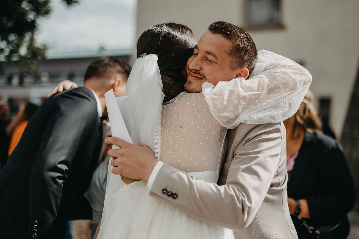 Romantic couple shares an intimate dance moment at their wedding reception in a dimly lit venue.