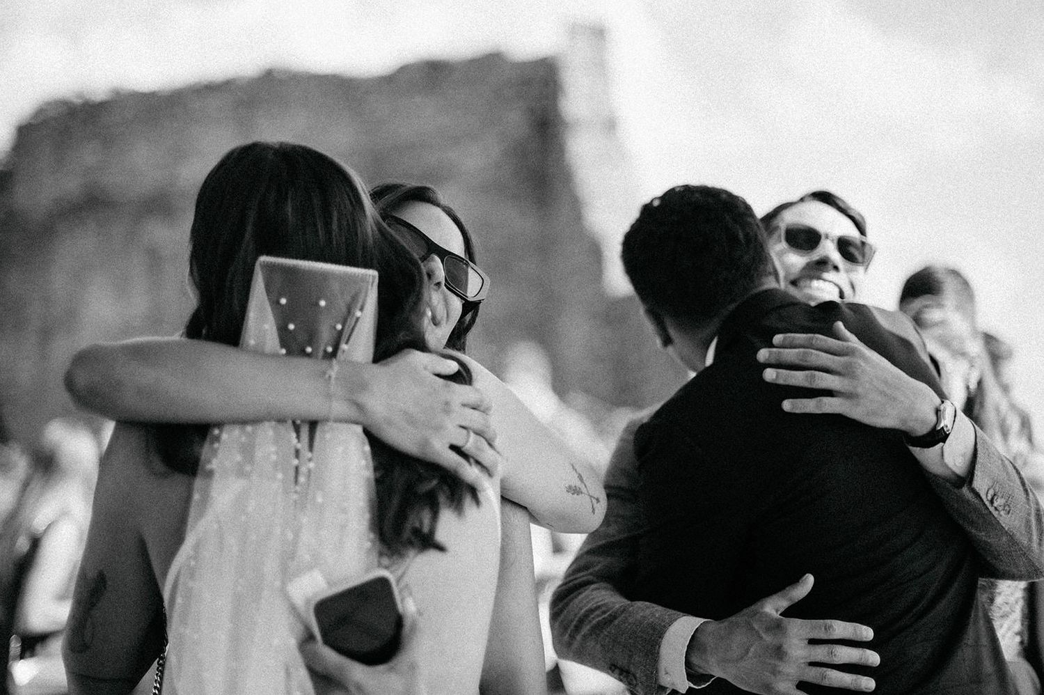 Black and white photo montage of couples embracing and dancing at what appears to be a wedding celebration.
