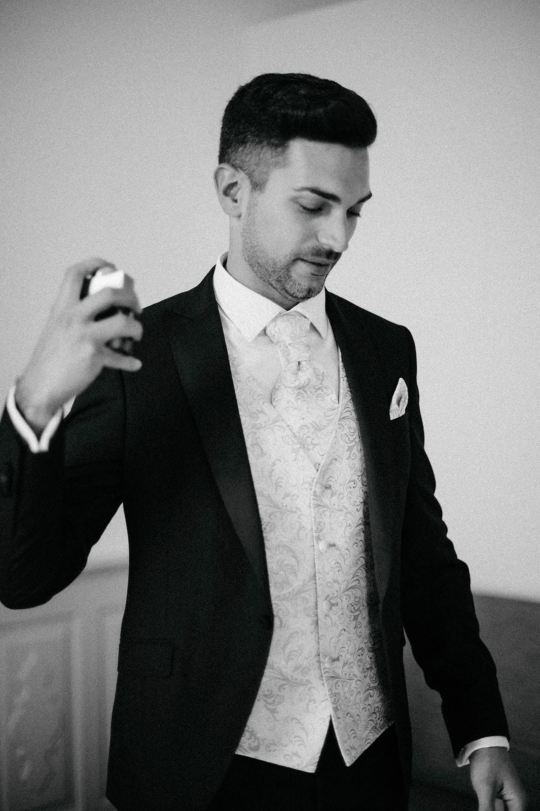 Black and white photo series showing a groom in formal attire with white vest and tie adjusting his suit.