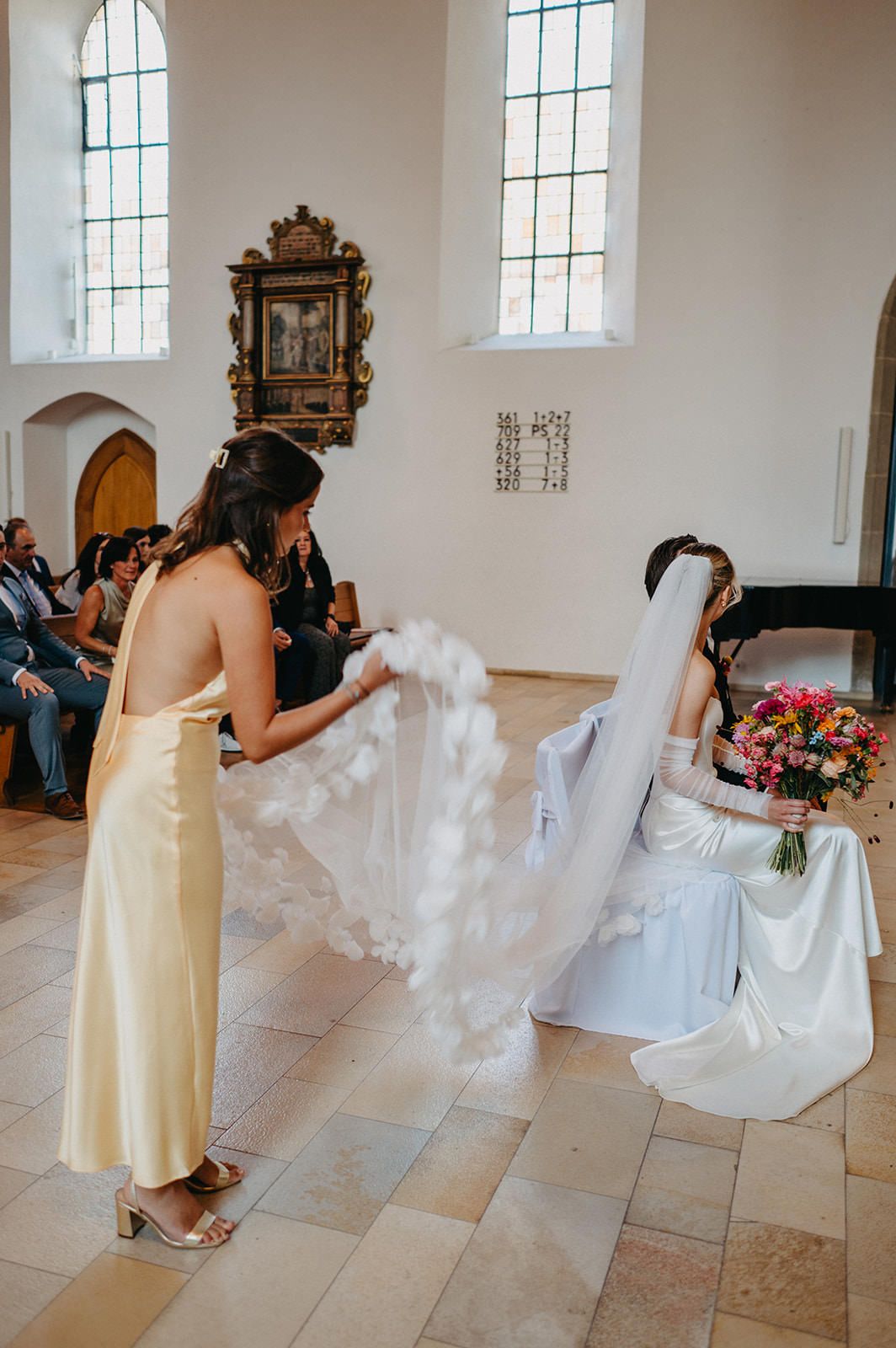 A sequence of photos showing bridesmaids in yellow dresses helping adjust a bride's wedding dress in a church setting.