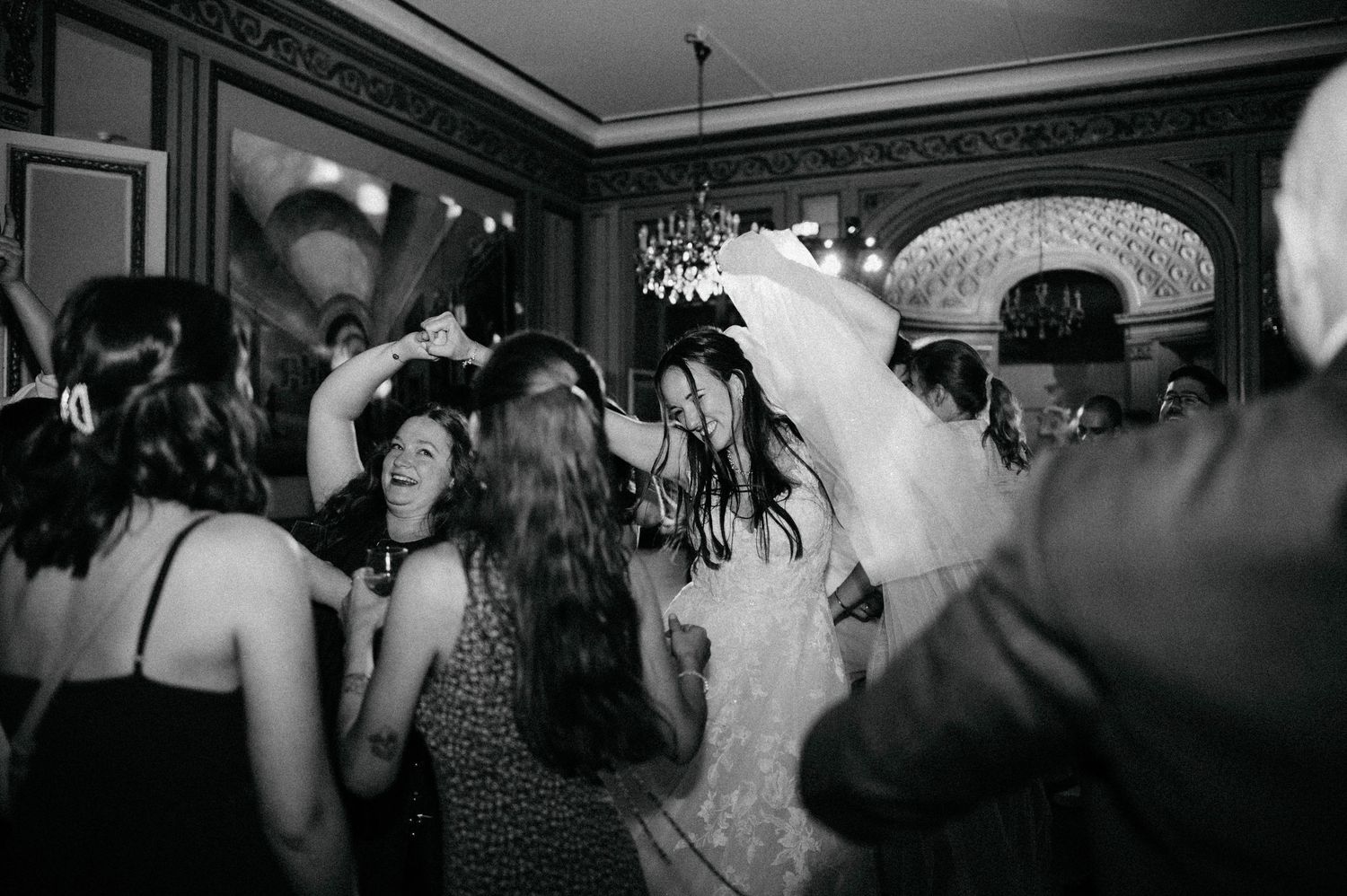 Black and white photos showing guests dancing and celebrating at a lively wedding reception.