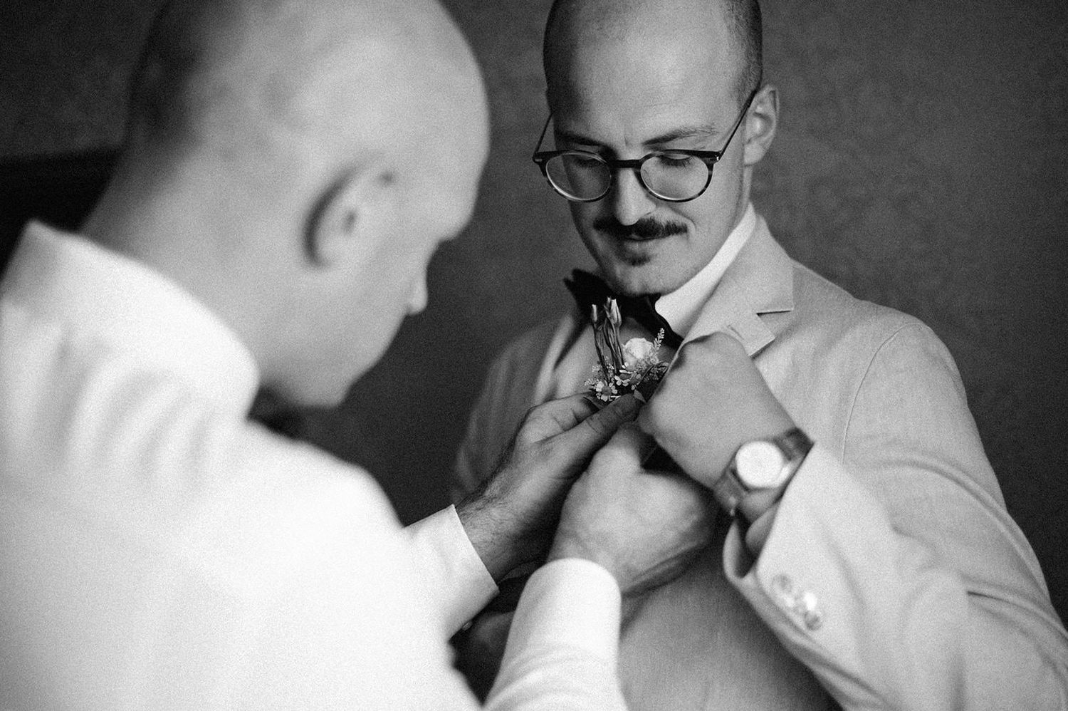 A series of monochrome images showing someone in glasses and formal attire preparing for an event.