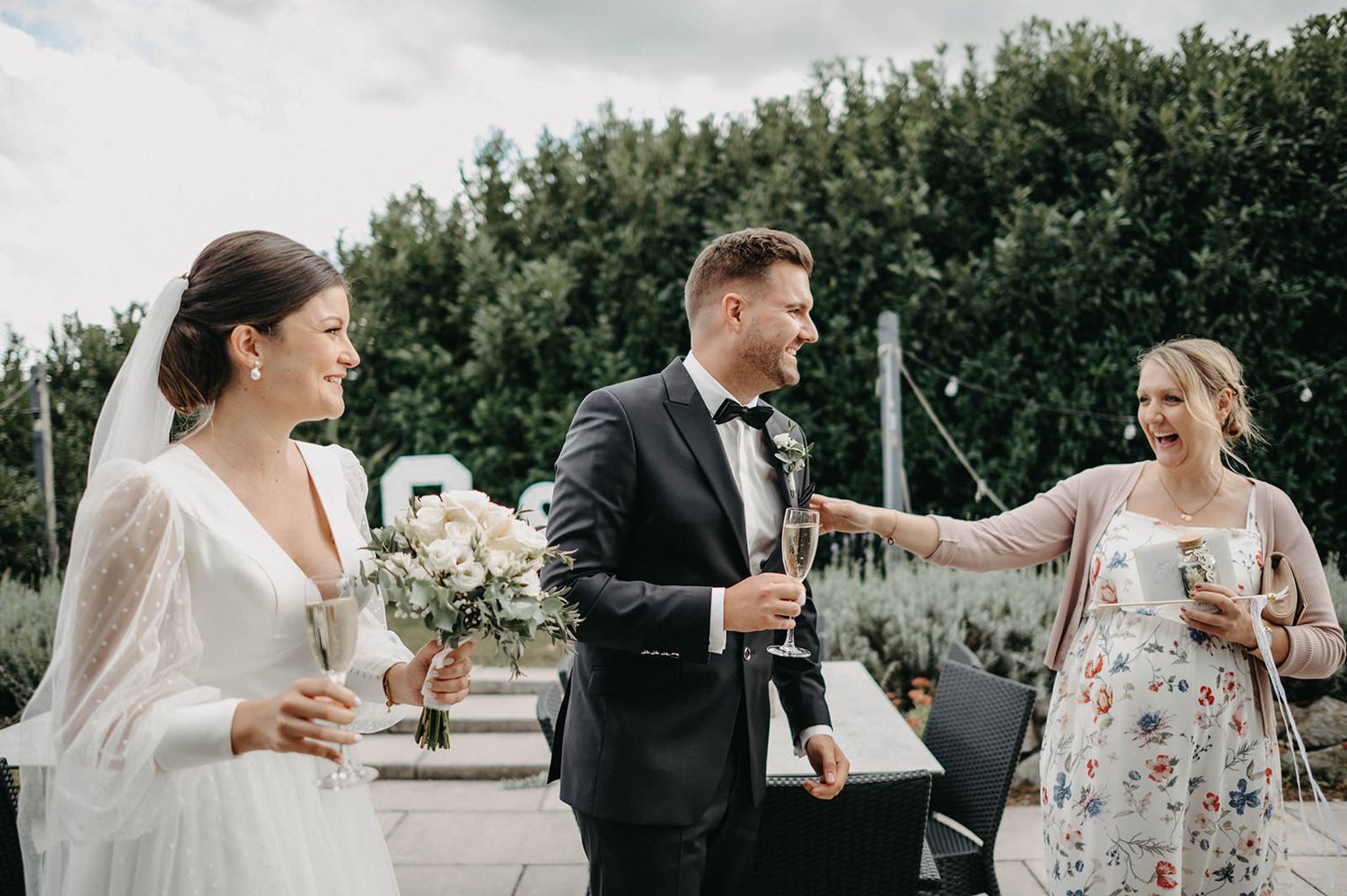 A series of candid wedding moments captured in black and white showing joyful interactions outdoors.