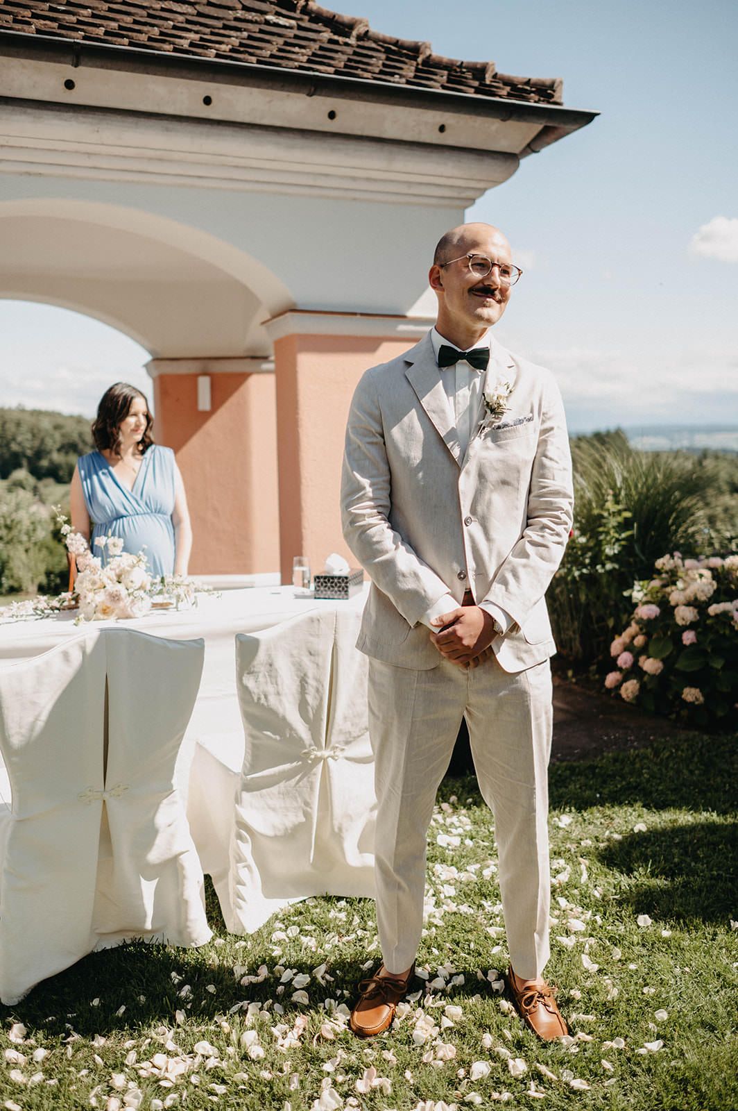 A series of outdoor wedding ceremony photos showing guests seated in white chairs on a grassy lawn with pink flowers.