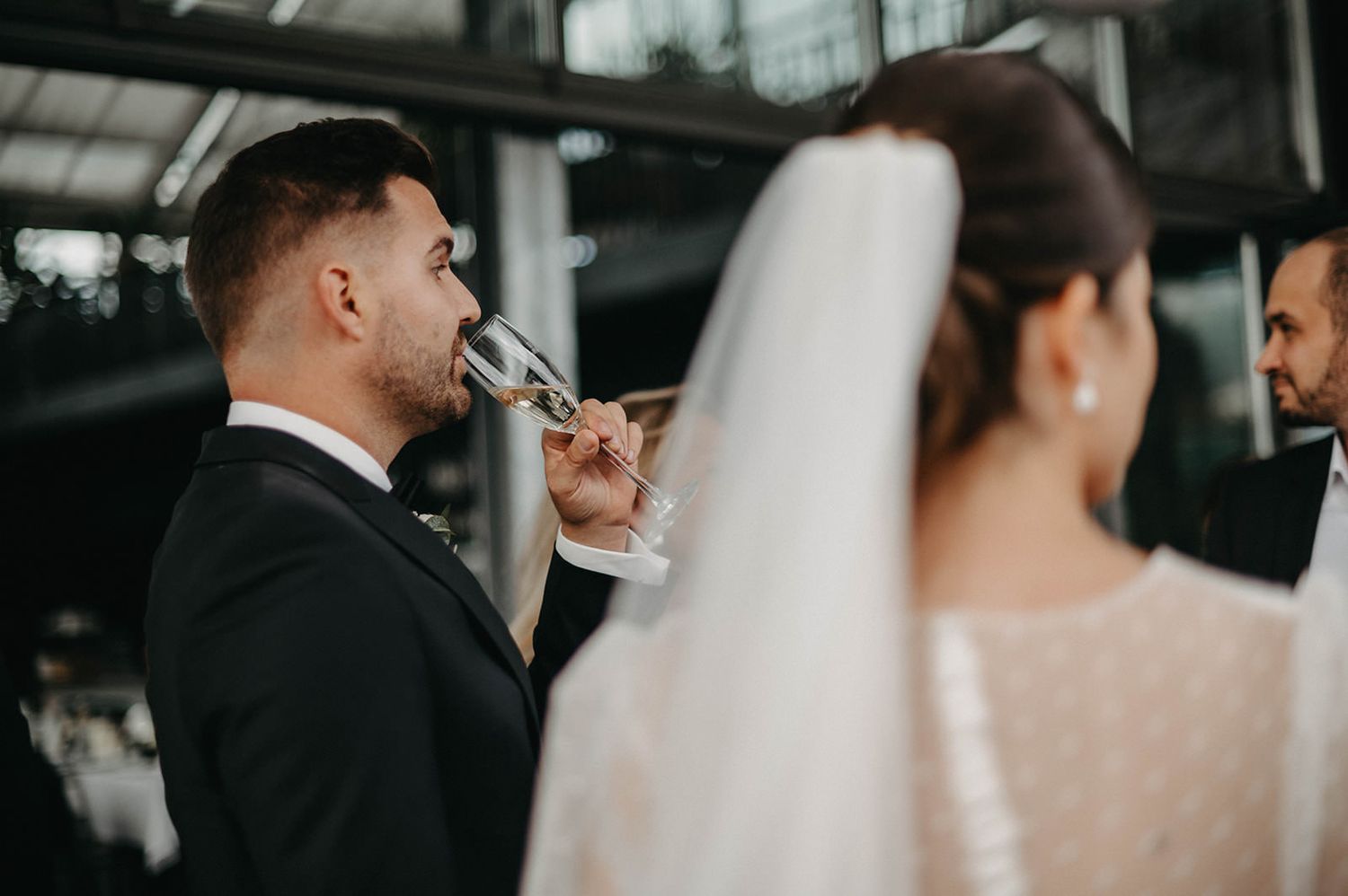 A bride and groom share an intimate moment during their wedding ceremony in an elegant indoor venue.