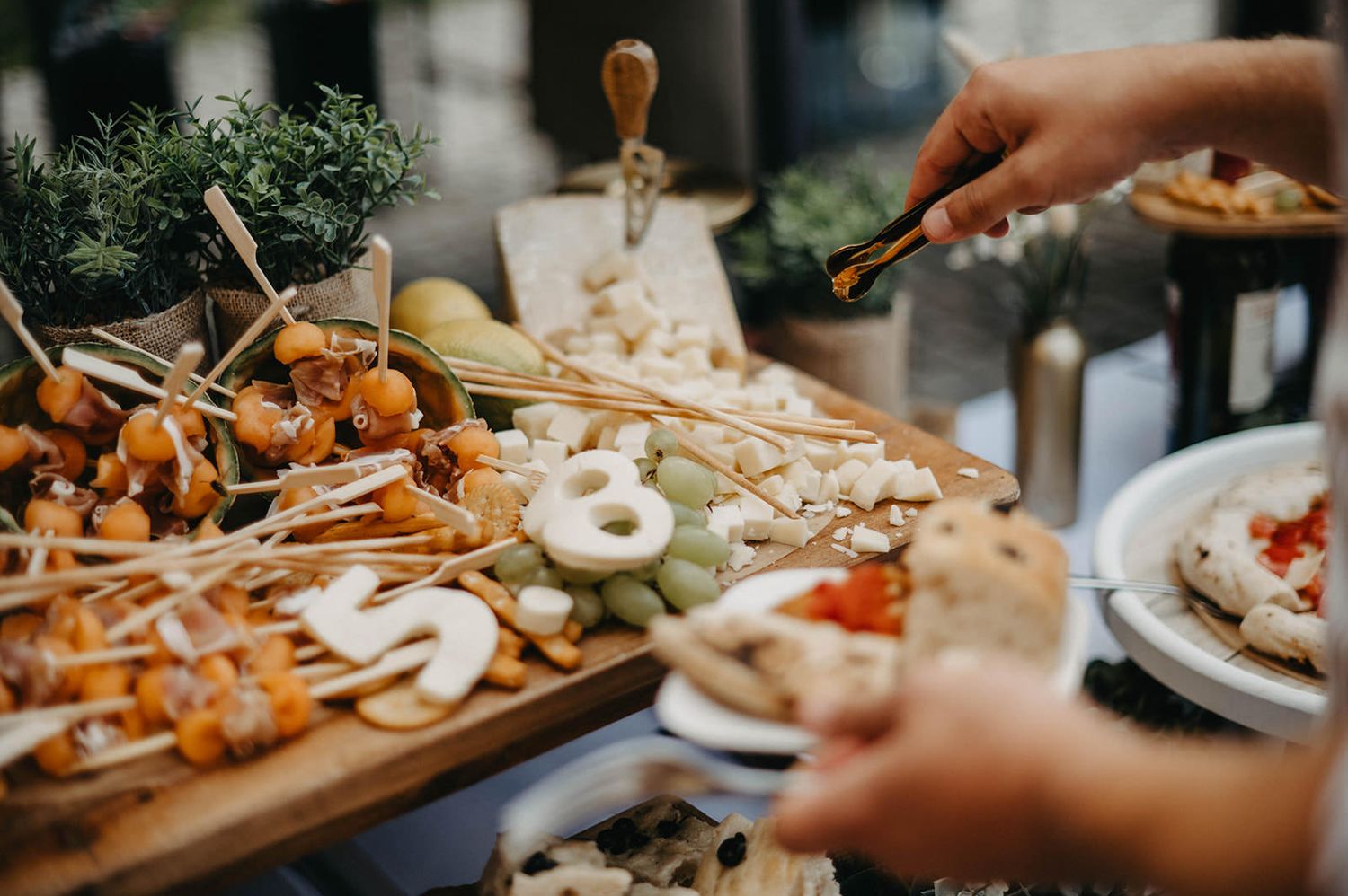 Wooden charcuterie boards filled with assorted meats, cheeses, fruits and nuts arranged on a rustic table.