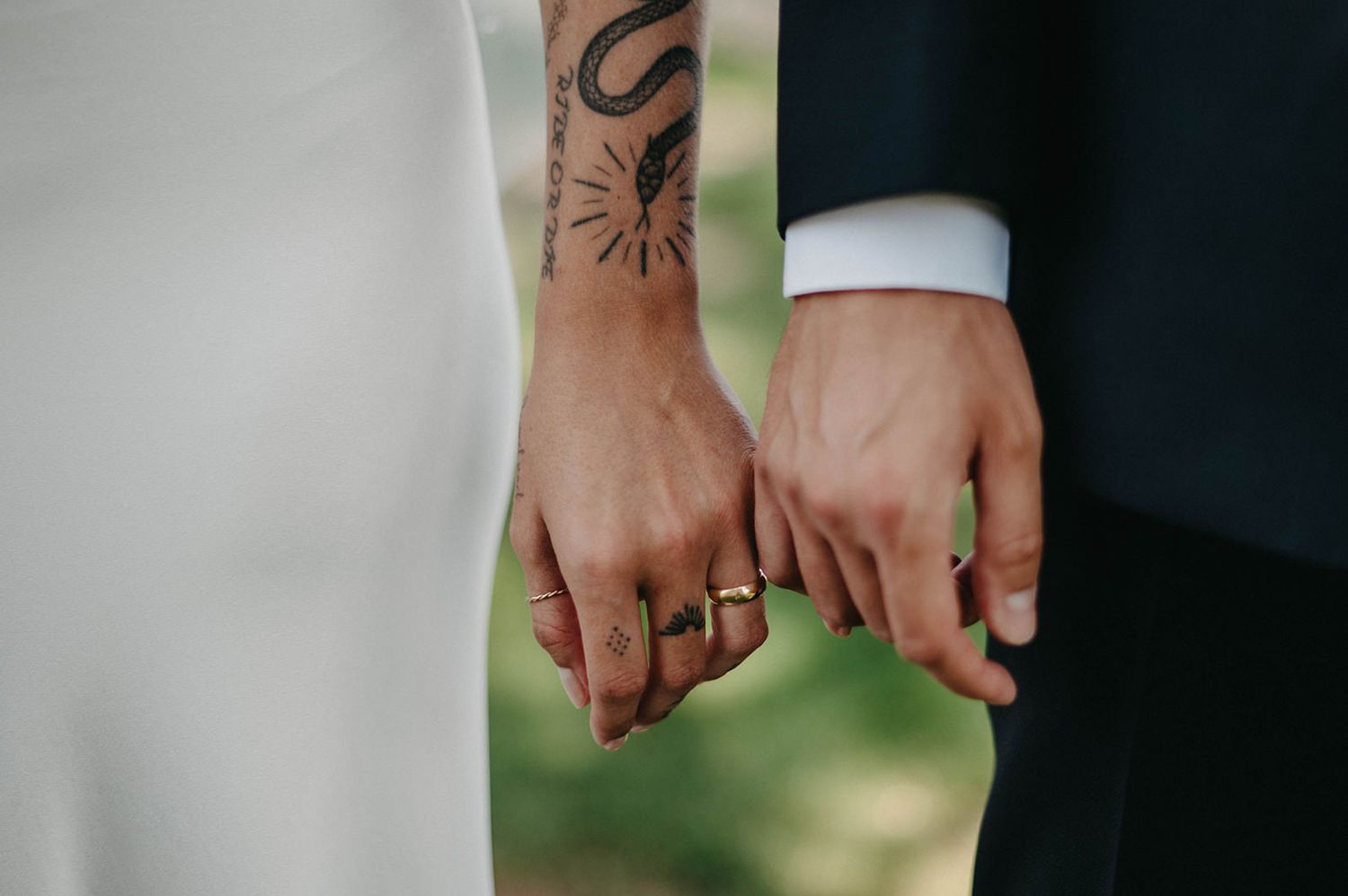 Close-up view of hands holding bouquets of white baby's breath flowers at an outdoor wedding ceremony.
